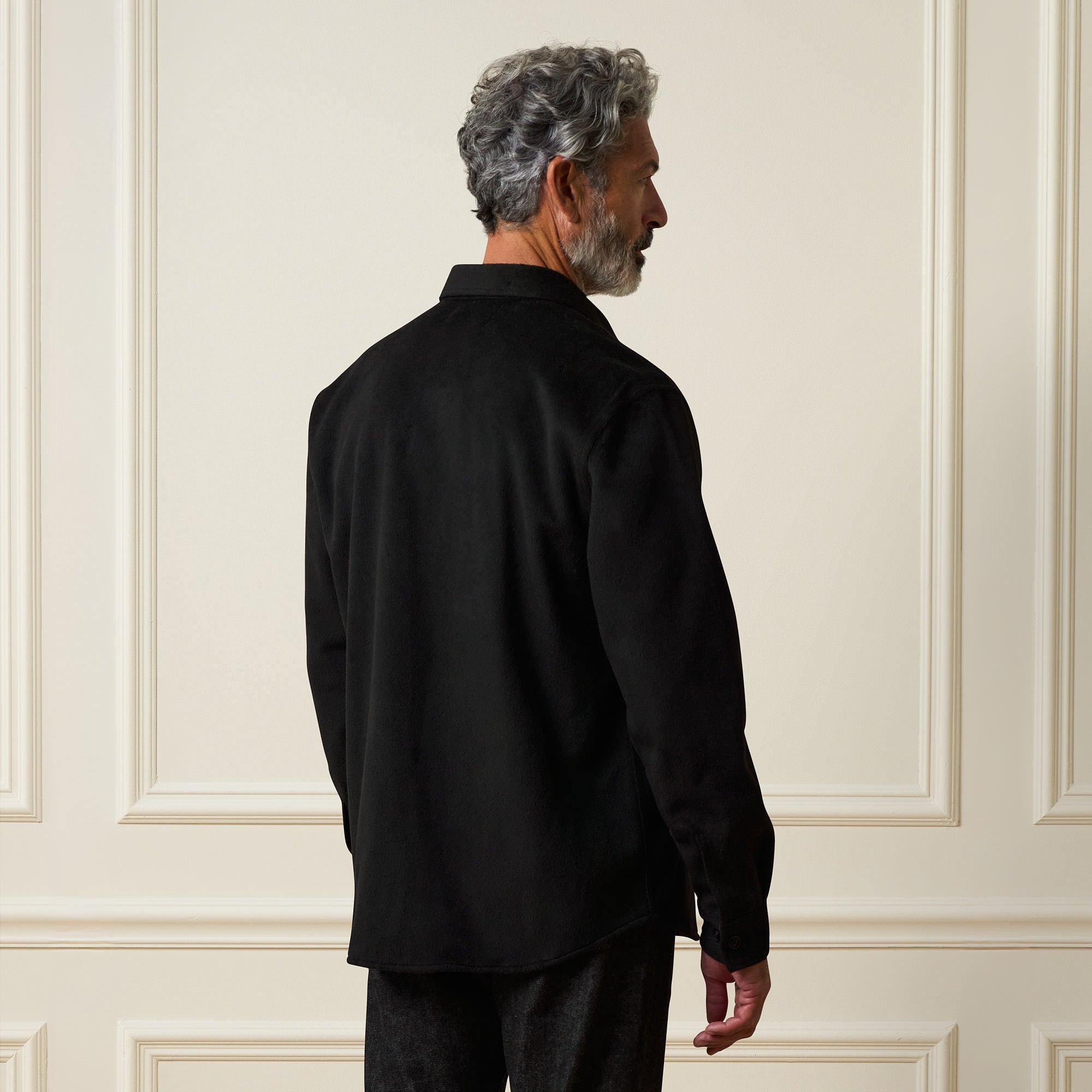 Man wearing a Faux Wool Shirt Jacket in Black, showing the back view against a minimalist backdrop.
