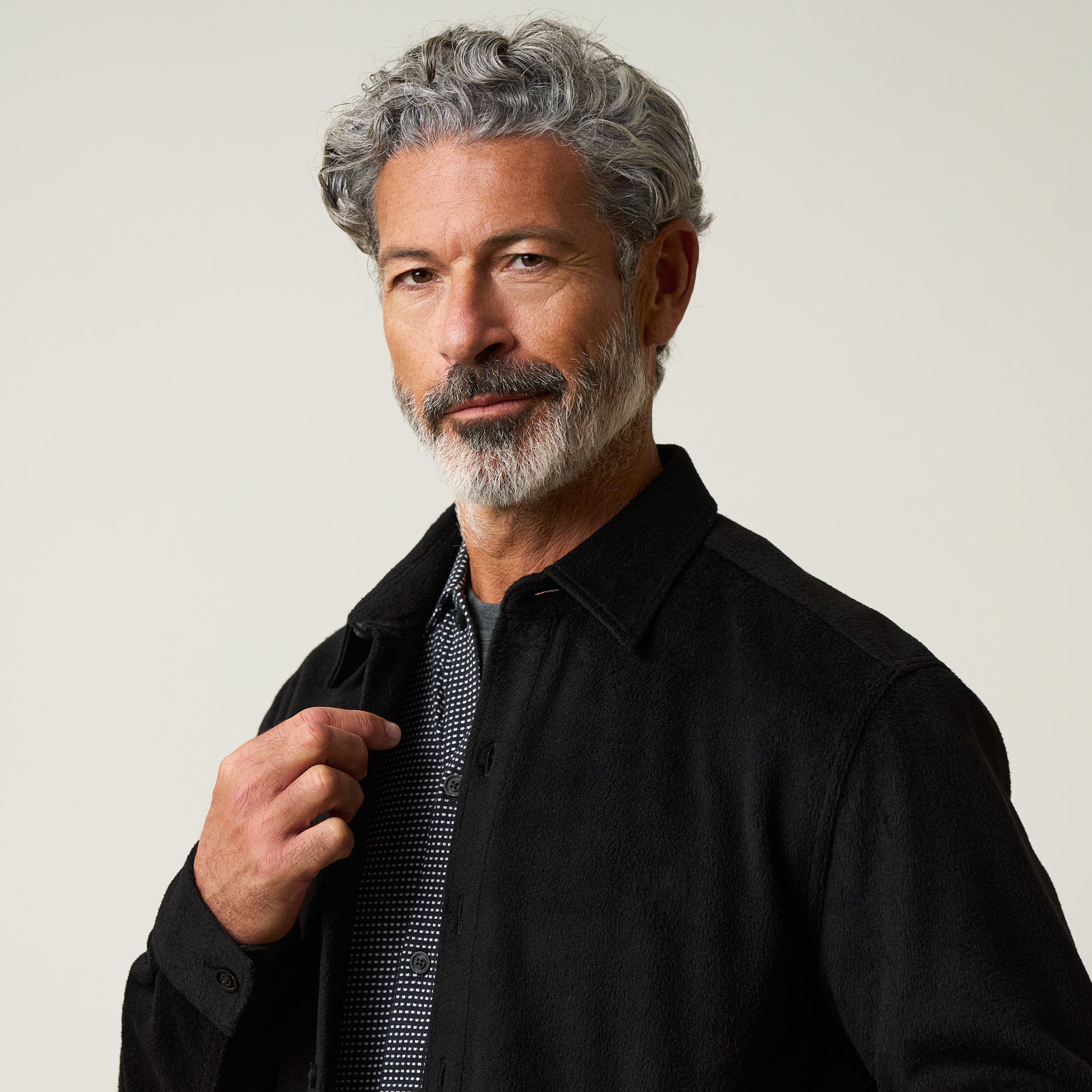 Faux Wool Shirt Jacket in Black worn by a model with gray hair and beard, showcasing a stylish button-up design.