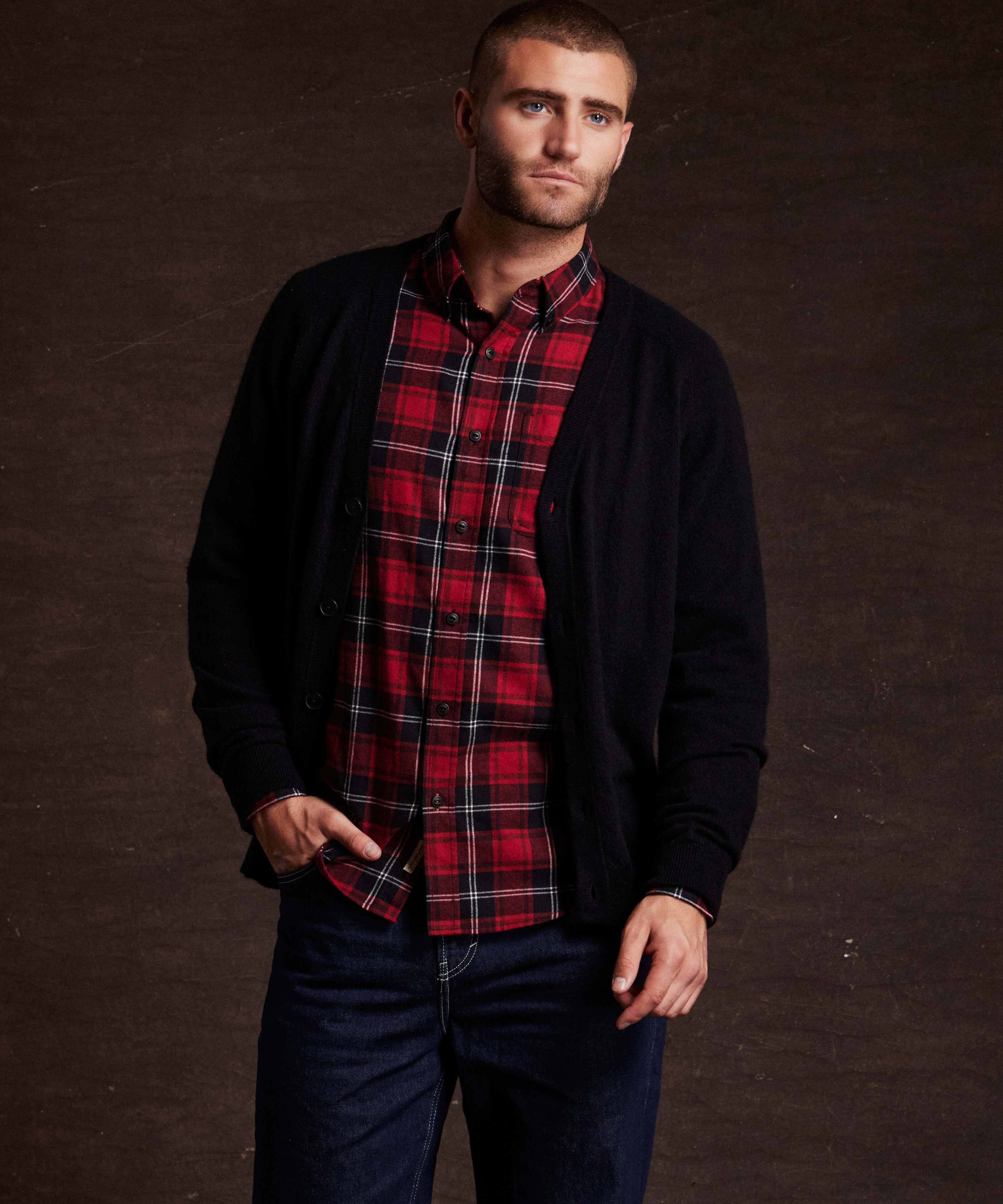Model wearing Holiday Antique Flannel in Tango Red with a black cardigan, showcasing a stylish and cozy winter look.