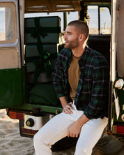 Model wearing Holiday Antique Flannel in Verdant Green, sitting in a vintage vehicle with holiday gifts.