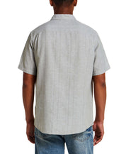 Back view of a model wearing a Linen Blend Dobby Stripe Shirt in Sea Grass, showcasing the short sleeves and subtle texture.