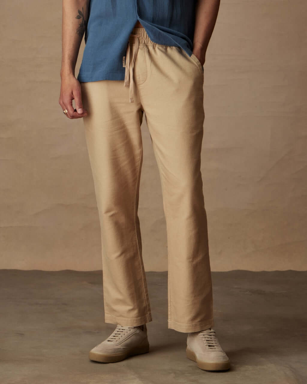 Linen blend drawstring pants in white pepper, featuring elastic waist and side pockets, modeled with a blue shirt.