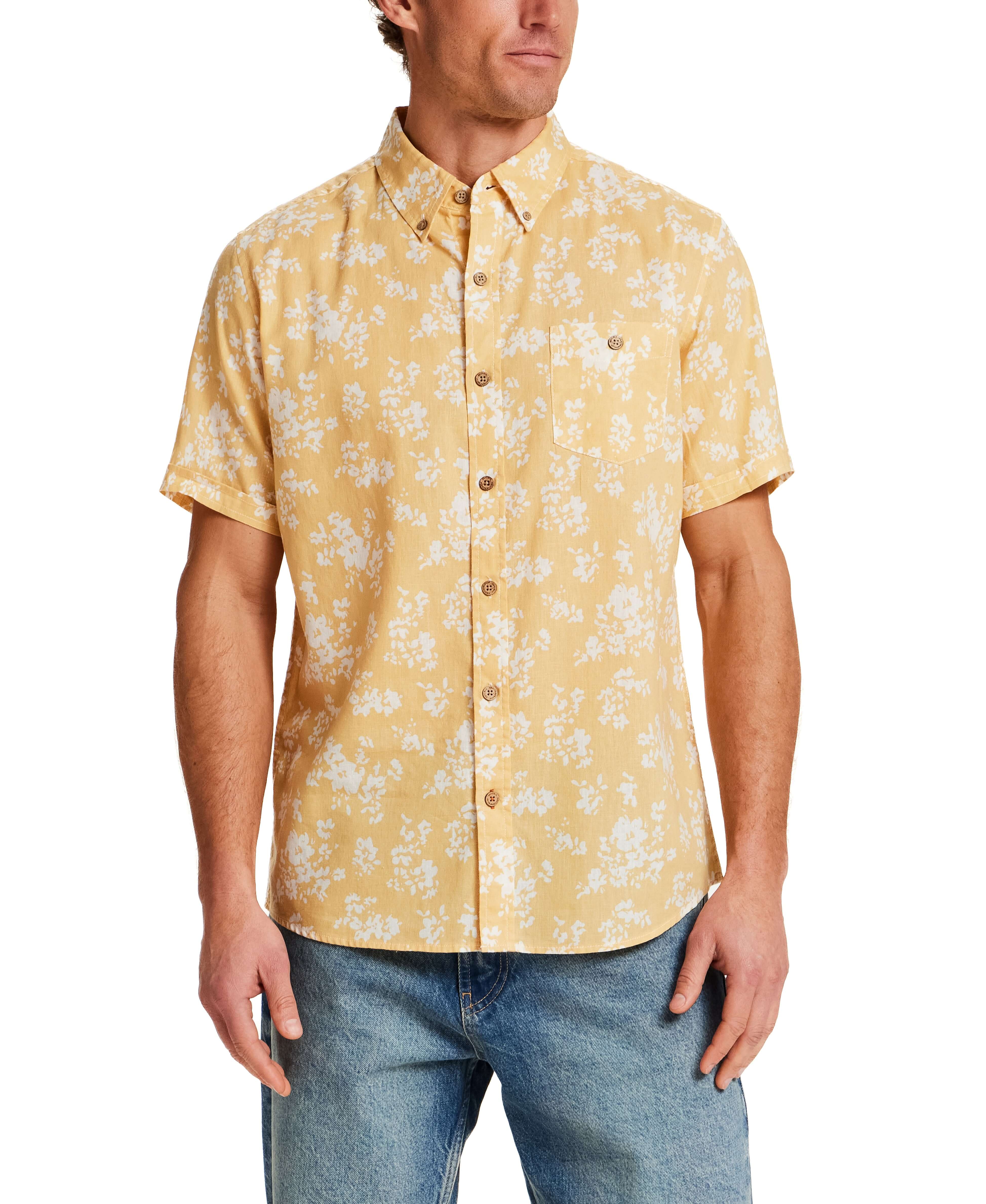 The Linen Cotton Print Shirt in Misted Yellow worn by a model, featuring a floral pattern and short sleeves.