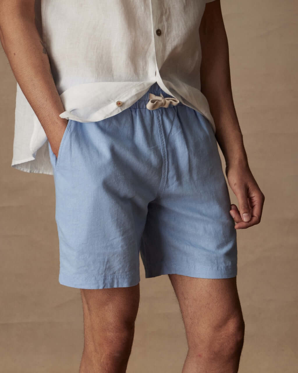 Breezy 7" linen shorts in fjord blue with elastic waist and adjustable drawcord, styled with a casual shirt.