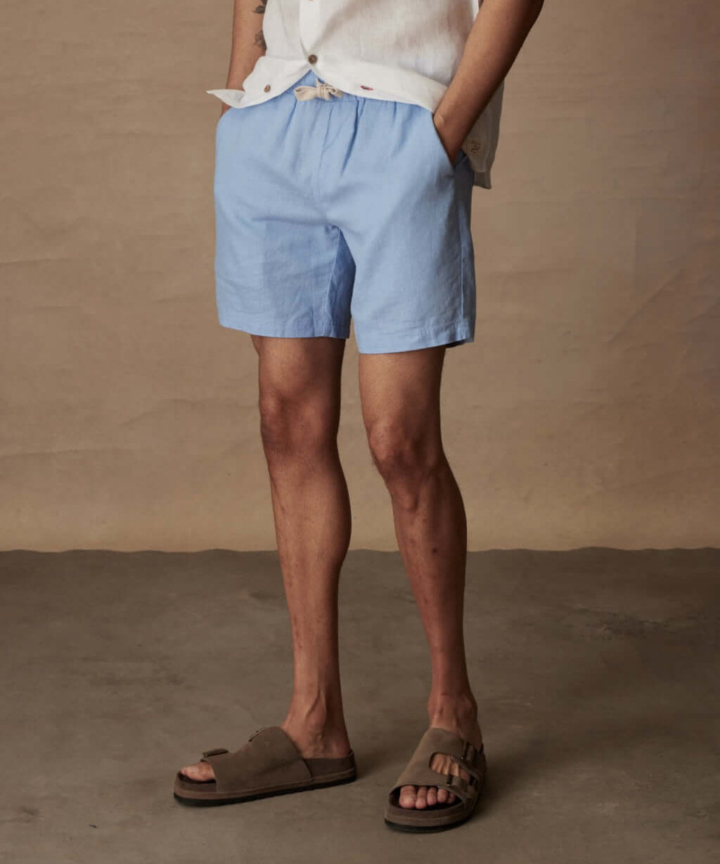Men's 7" linen shorts in fjord blue with elastic waist and pockets, perfect for casual summer wear.