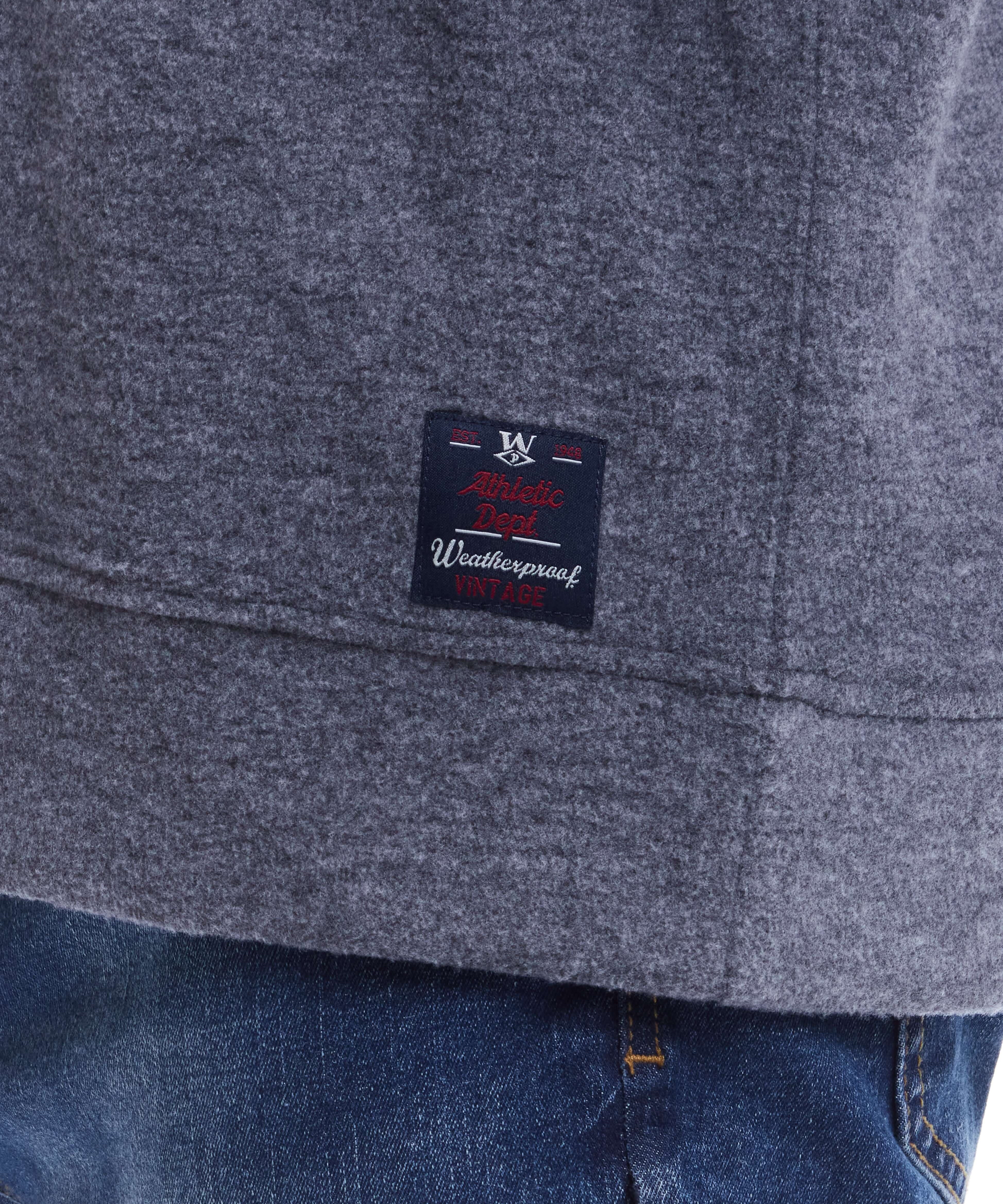 Close-up of the label on a grey long sleeve brushed crew, featuring weatherproof branding and soft fabric detail.