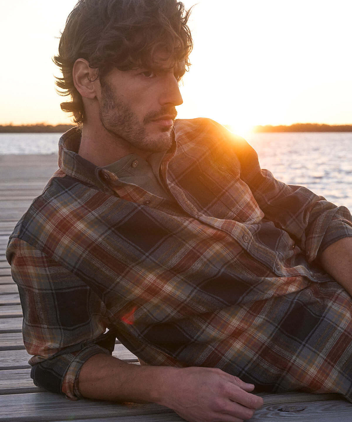 Model wearing Long Sleeve Brushed Flannel in Bombay Brown by the sunset on a pier.