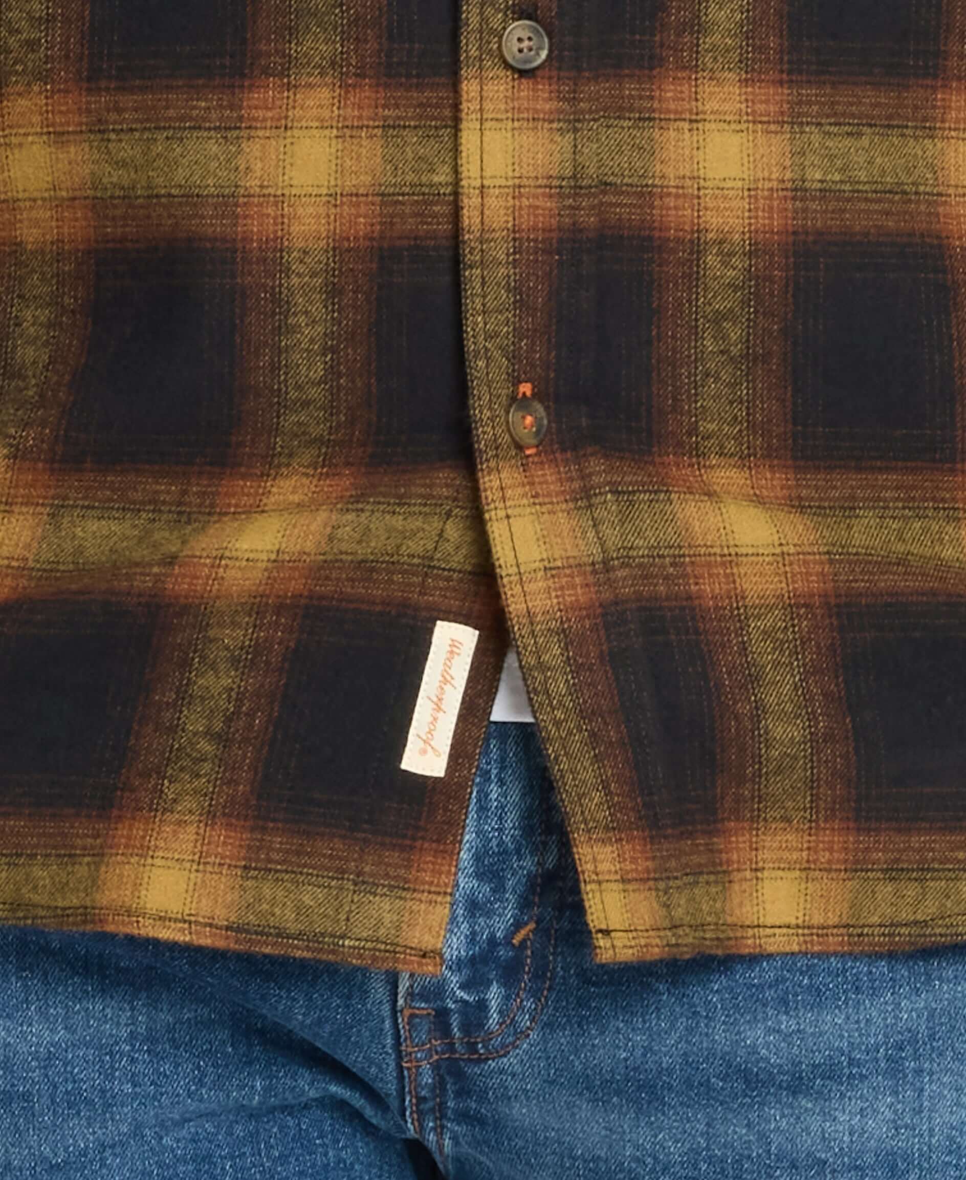 Long sleeve brushed flannel shirt in Inca Gold featuring plaid pattern and button-down collar, layered over jeans.