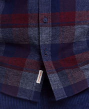 Close-up of a long sleeve brushed flannel shirt in red maroon plaid pattern, featuring a button-down collar and pocket.