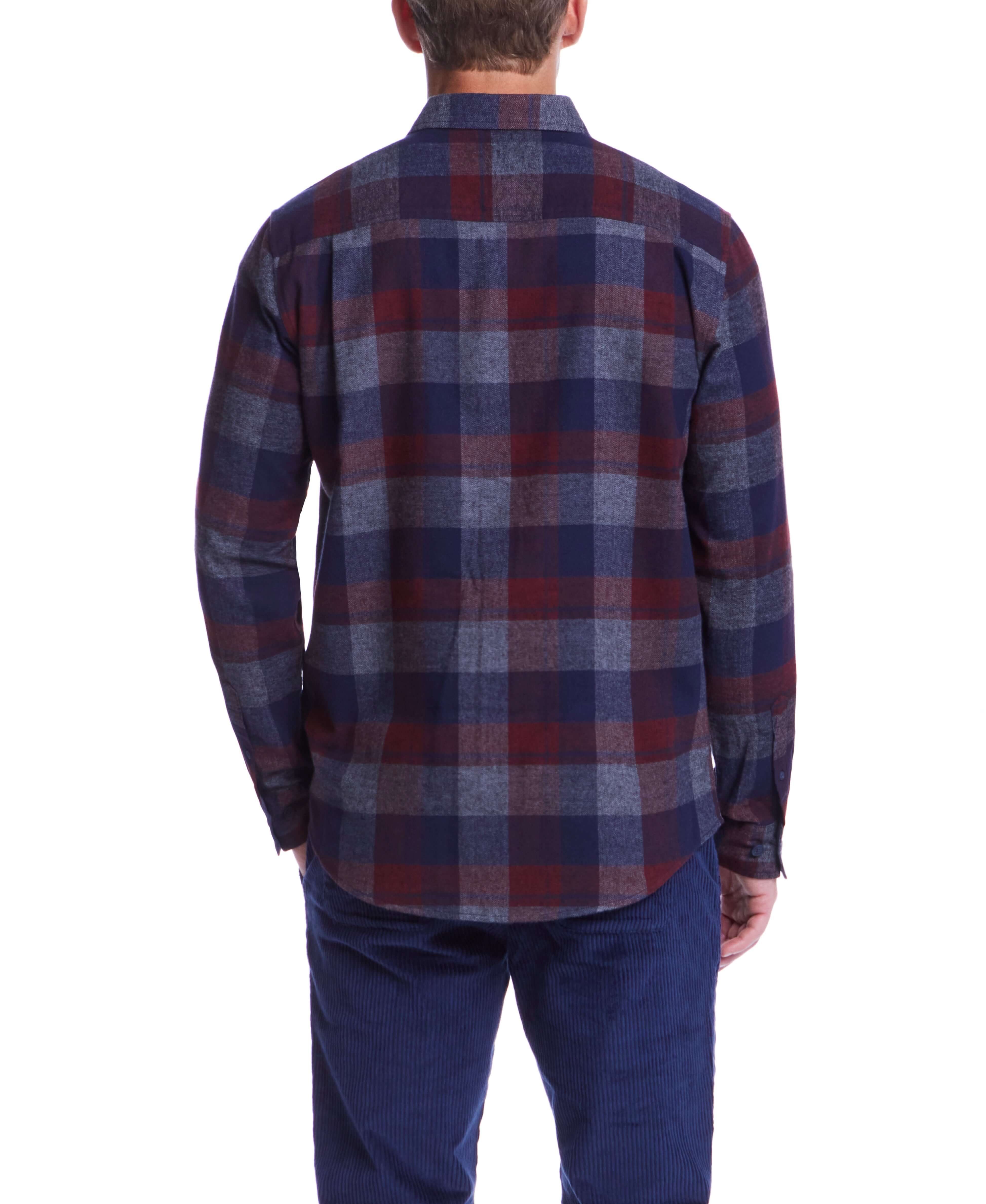 Back view of a man wearing a long sleeve red maroon brushed flannel shirt with a classic plaid pattern.