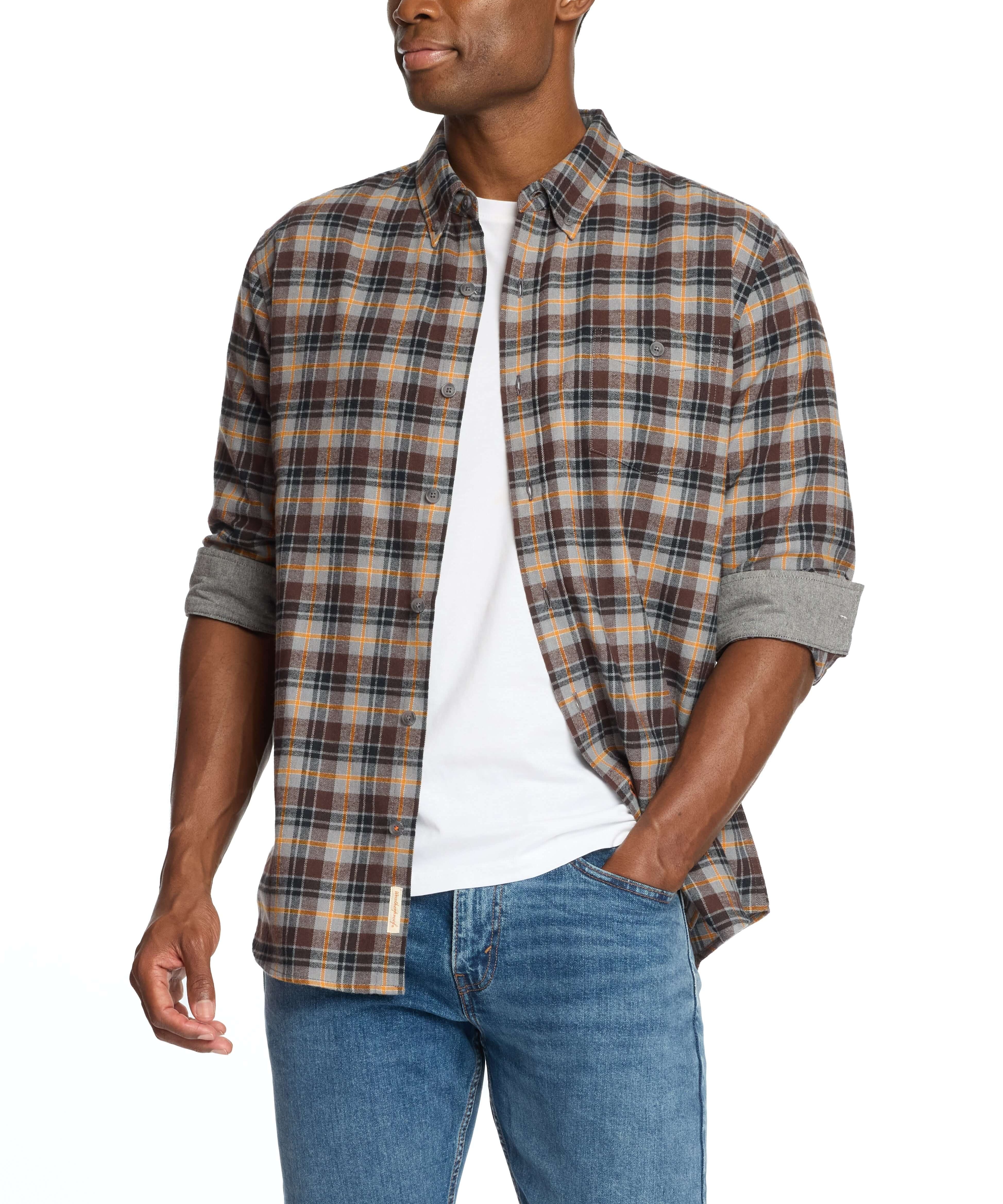Man wearing a long sleeve brushed flannel shirt in sharkskin with a plaid pattern and rolled sleeves.