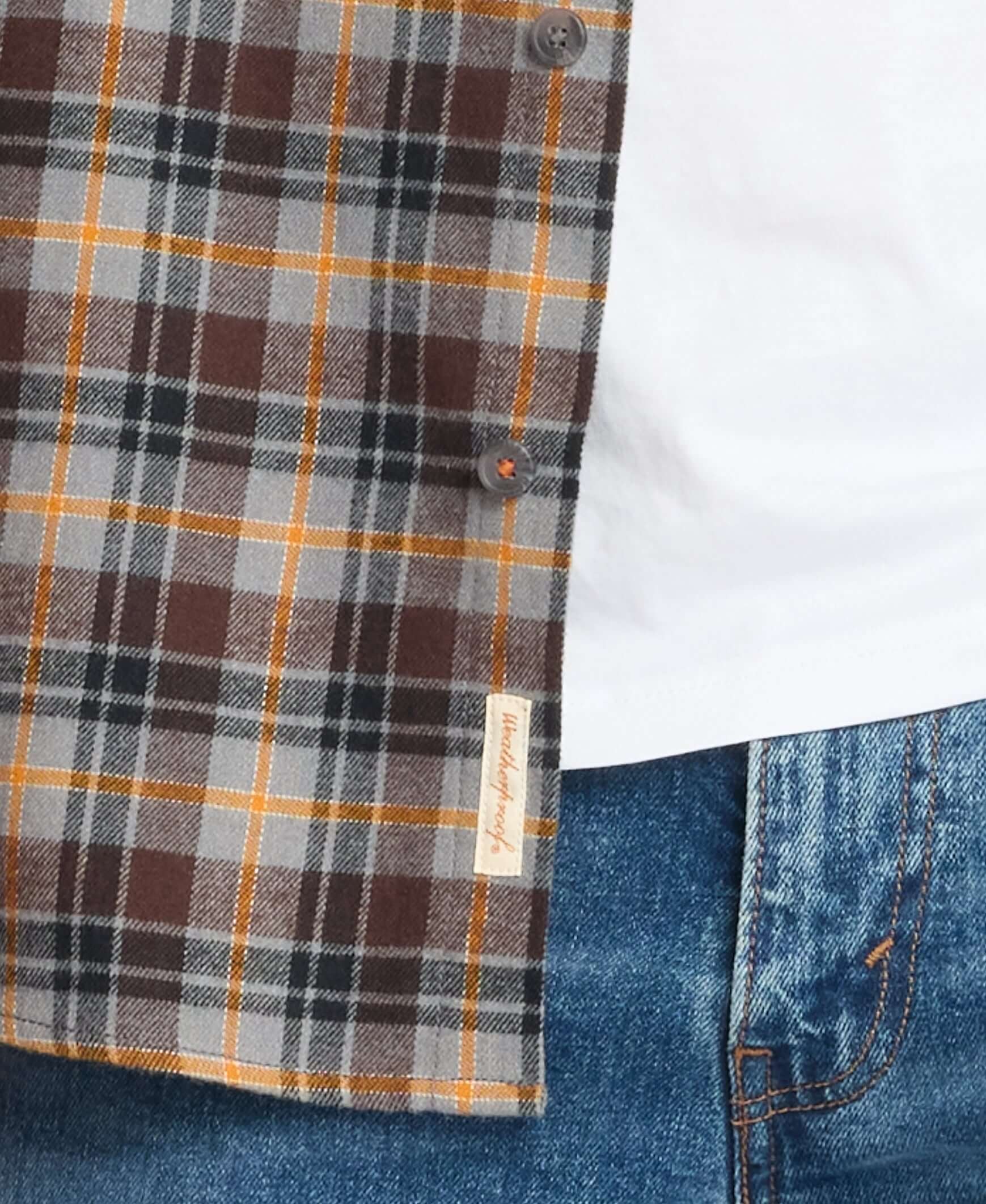 Close-up of long sleeve brushed flannel shirt in sharkskin, featuring plaid pattern and button details.
