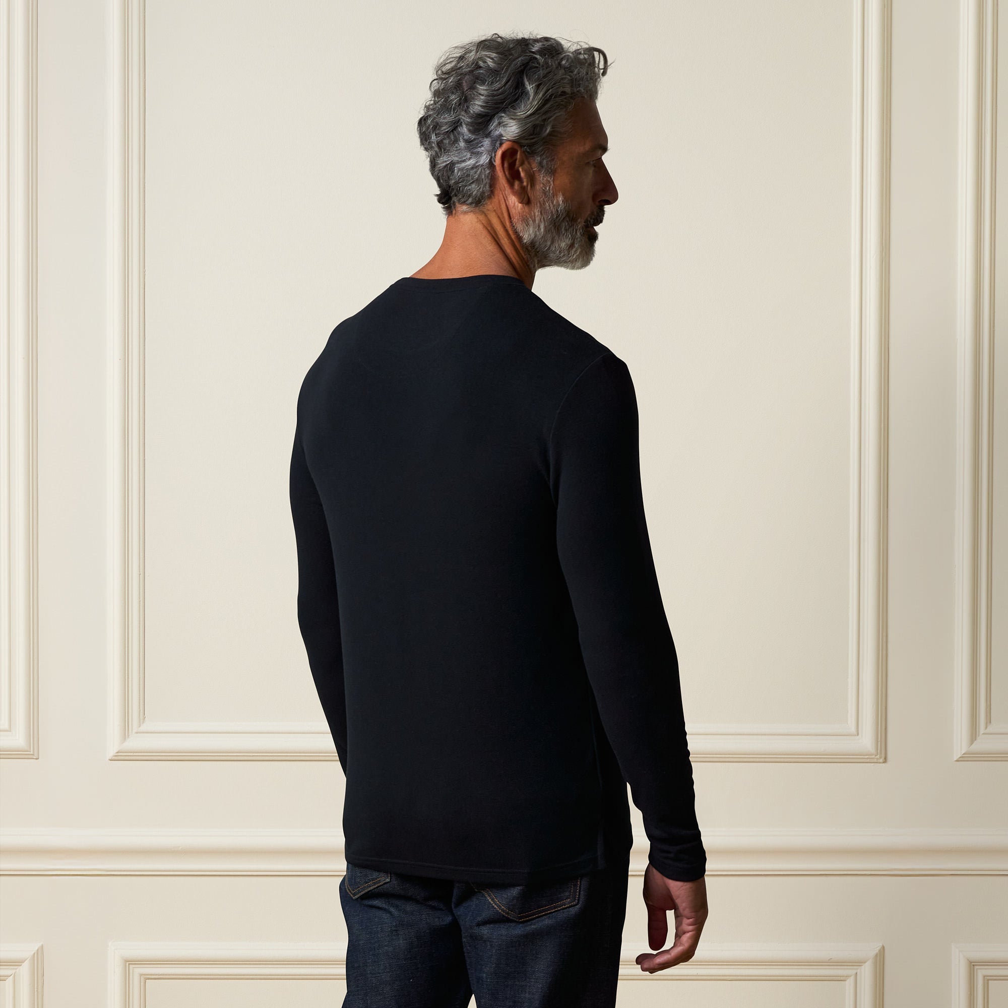 Long Sleeve Crew Neck in Black, showcasing the back view of a man wearing a smooth black layering piece.