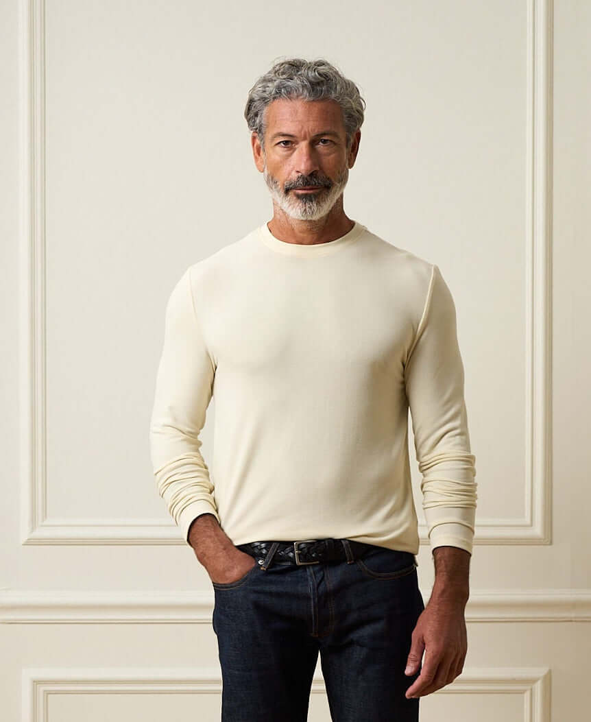 Long Sleeve Crew Neck in Ivory worn by a man against a neutral backdrop, showcasing its soft fabric and relaxed fit.