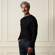Long Sleeve Crinkle Henley in Black worn by a man, showcasing its textured fabric and relaxed fit.