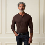 Long Sleeve Crinkle Henley in Brown worn by a man, featuring a button placket and long sleeves with a textured design.