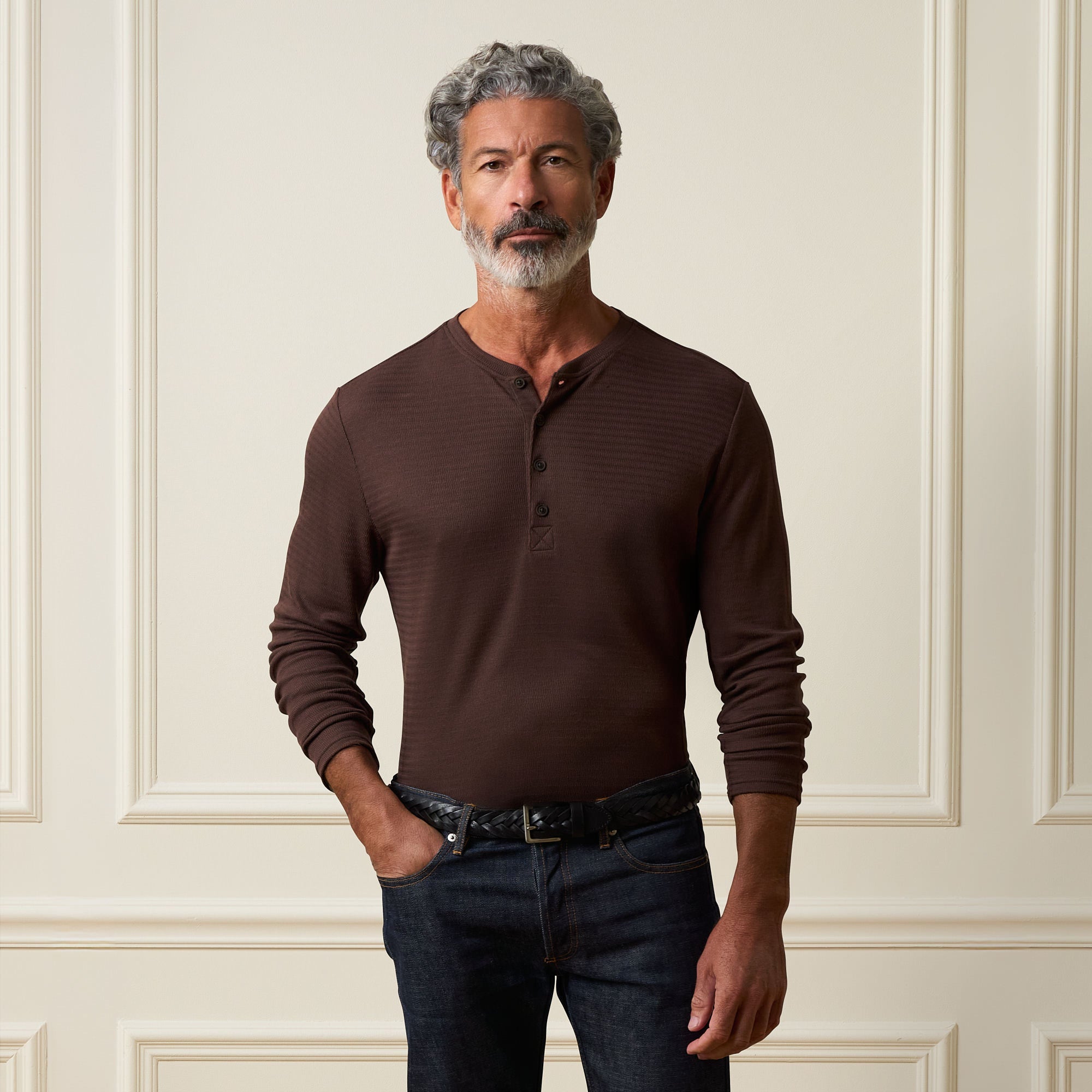 Long Sleeve Crinkle Henley in Brown worn by a man, featuring a button placket and long sleeves with a textured design.