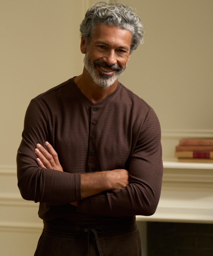Long Sleeve Crinkle Henley in Brown worn by a smiling man with gray hair and beard, featuring a button placket and relaxed fit.
