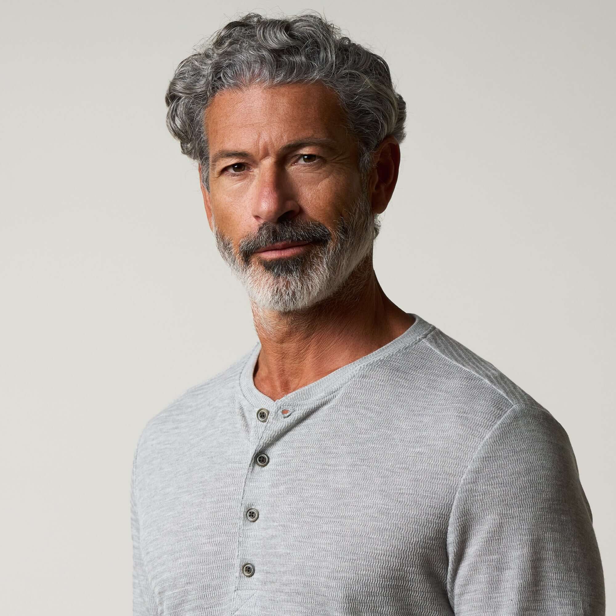 Long Sleeve Crinkle Henley in Grey Heather worn by a man, showcasing its modern and relaxed style with a Henley neckline.