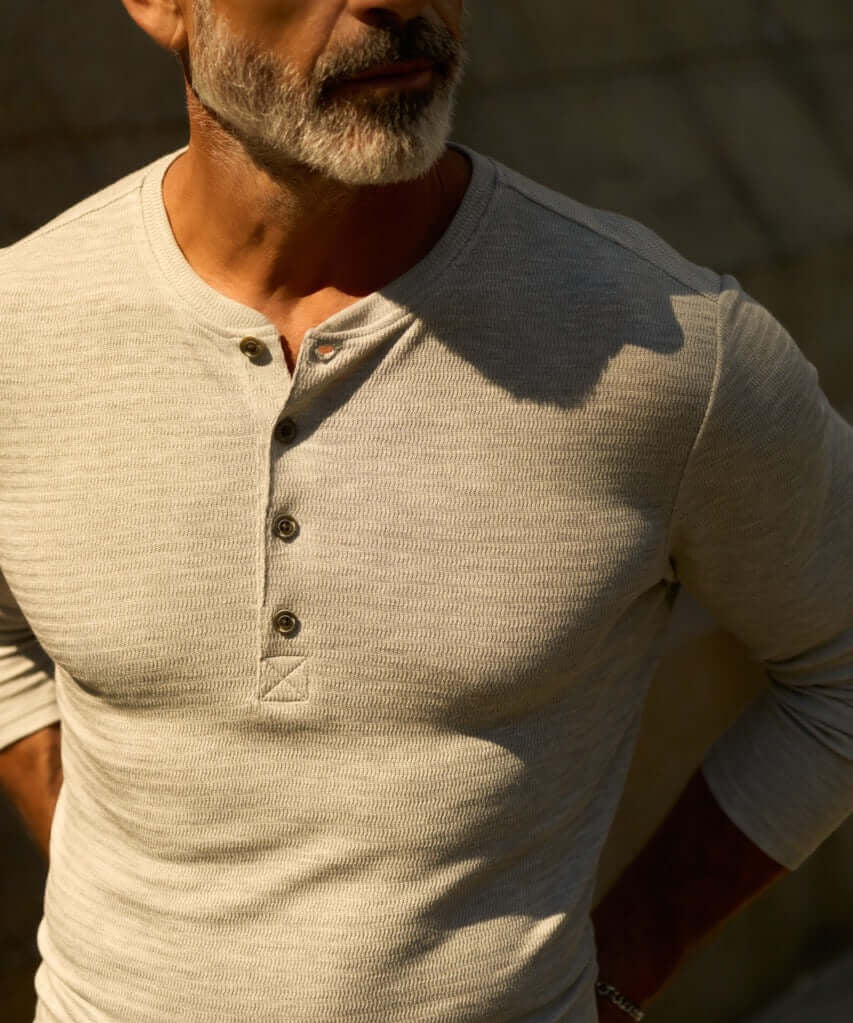 Long Sleeve Crinkle Henley in Grey Heather worn by a man, showcasing its lightweight texture and stylish button placket.