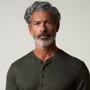 Long Sleeve Crinkle Henley in Olive worn by a man with grey hair and beard.