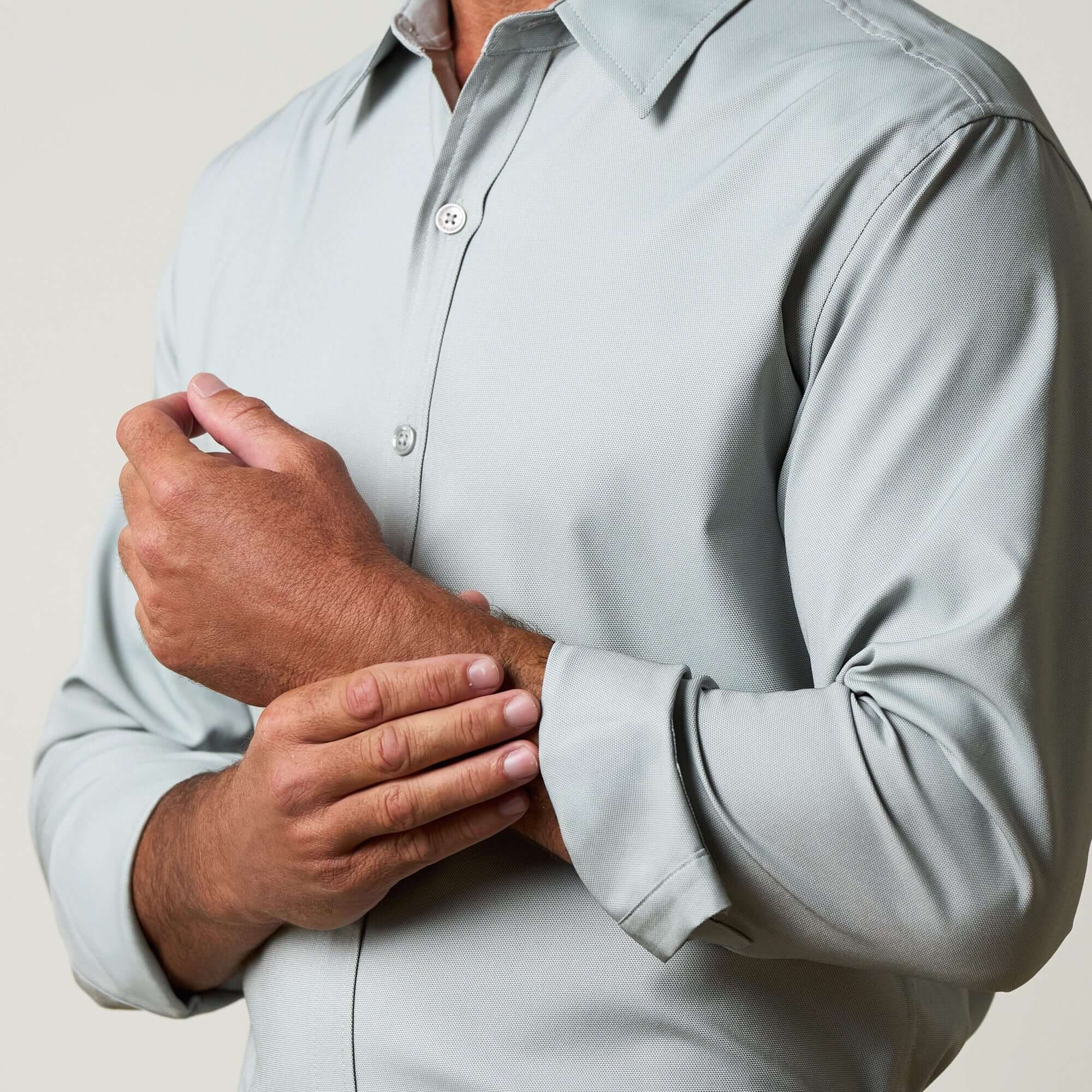 Close-up of a man adjusting his cuff in a Long Sleeve Shirt in Medium Grey.