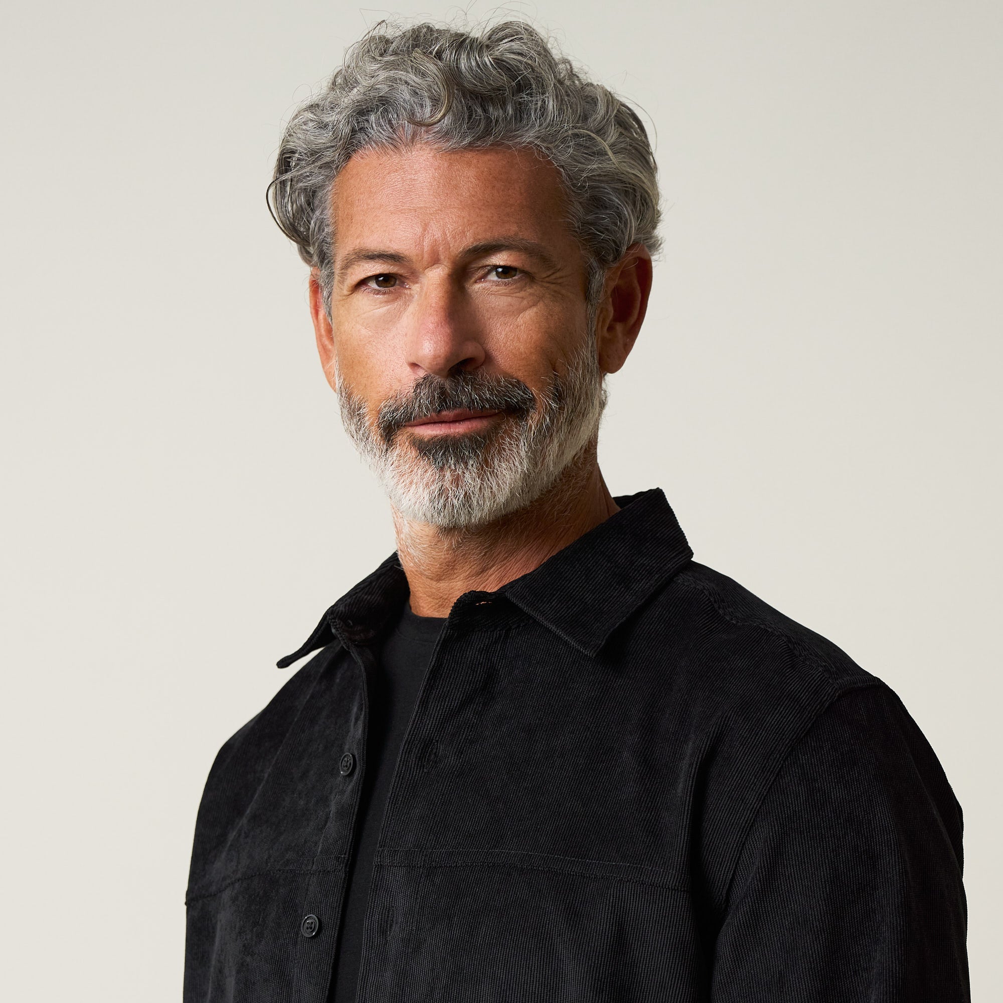 Long Sleeve Solid Cord Button Down in Black, featuring a model wearing a soft corduroy shirt with button front.