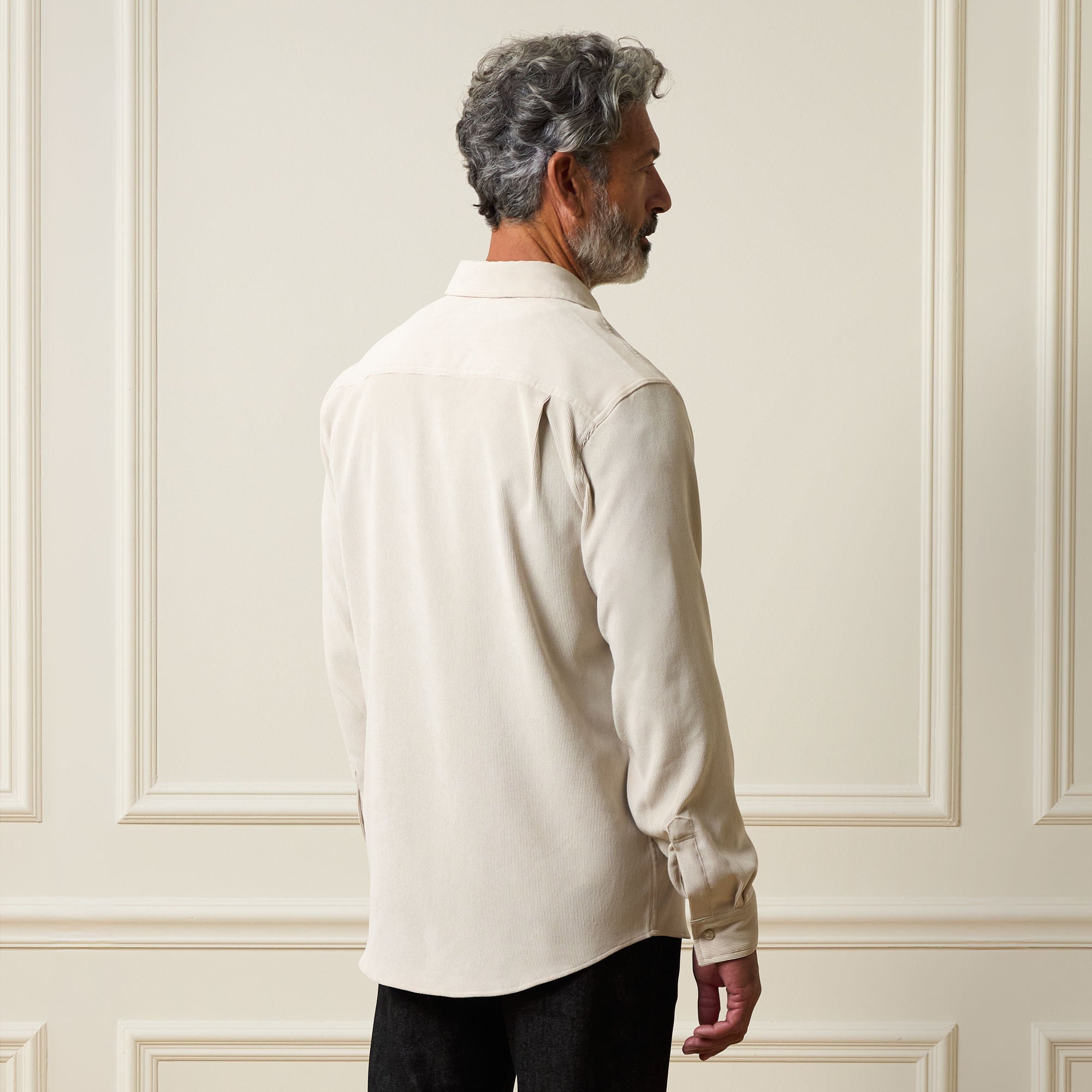 Long Sleeve Solid Cord Button Down Cream worn from the back, showcasing its soft texture and button cuff details.