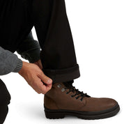 Person adjusting laces on brown boots while wearing regular fit fleece lined jeans and a grey sweater.