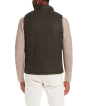 Model wearing the Matte Coated Shell Puffer Vest in Kambaba Olive from the back, showcasing its sleek design and classic fit.