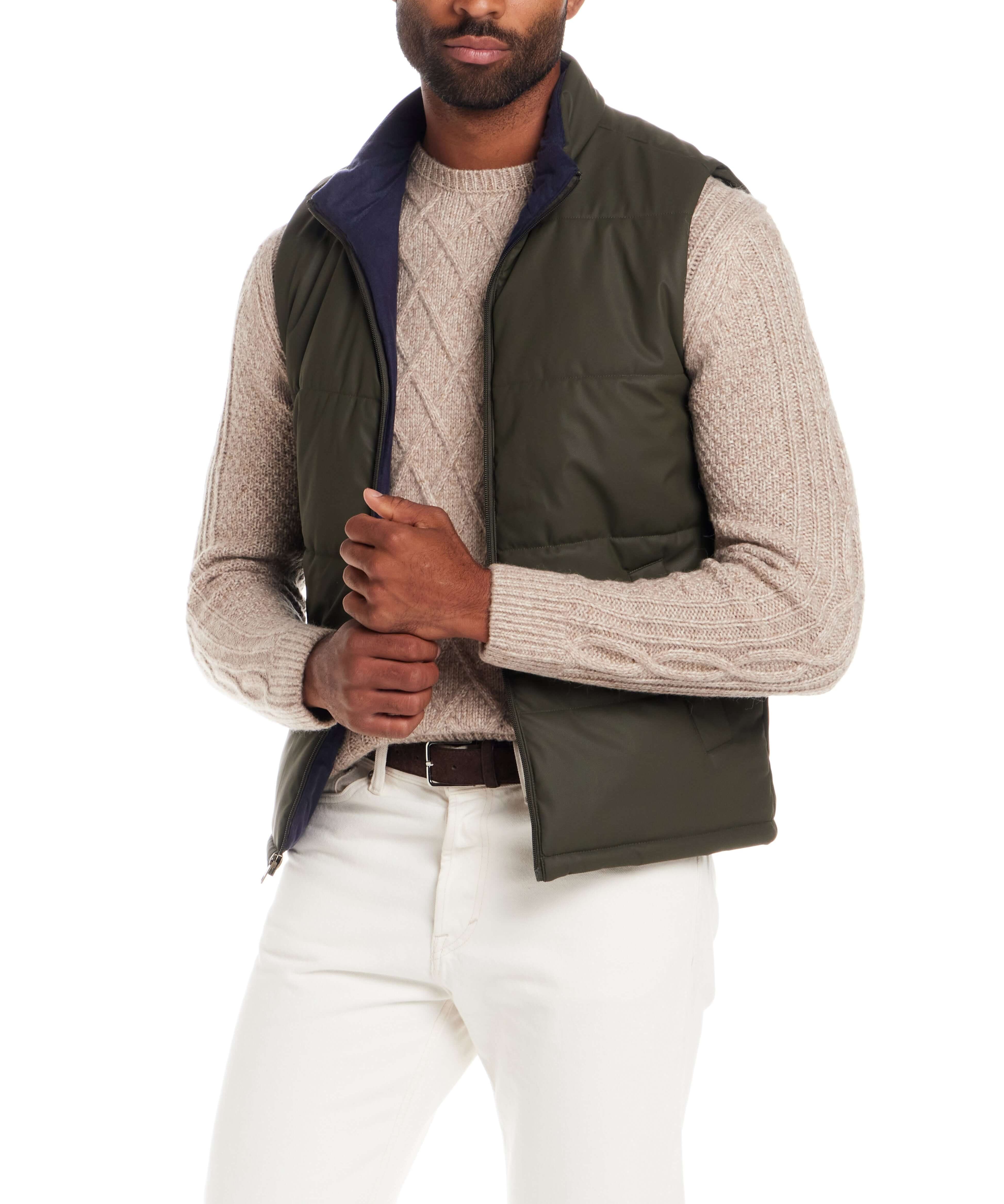 Matte Coated Shell Puffer Vest in Kambaba Olive worn by a model, styled with a knitted sweater and white pants.