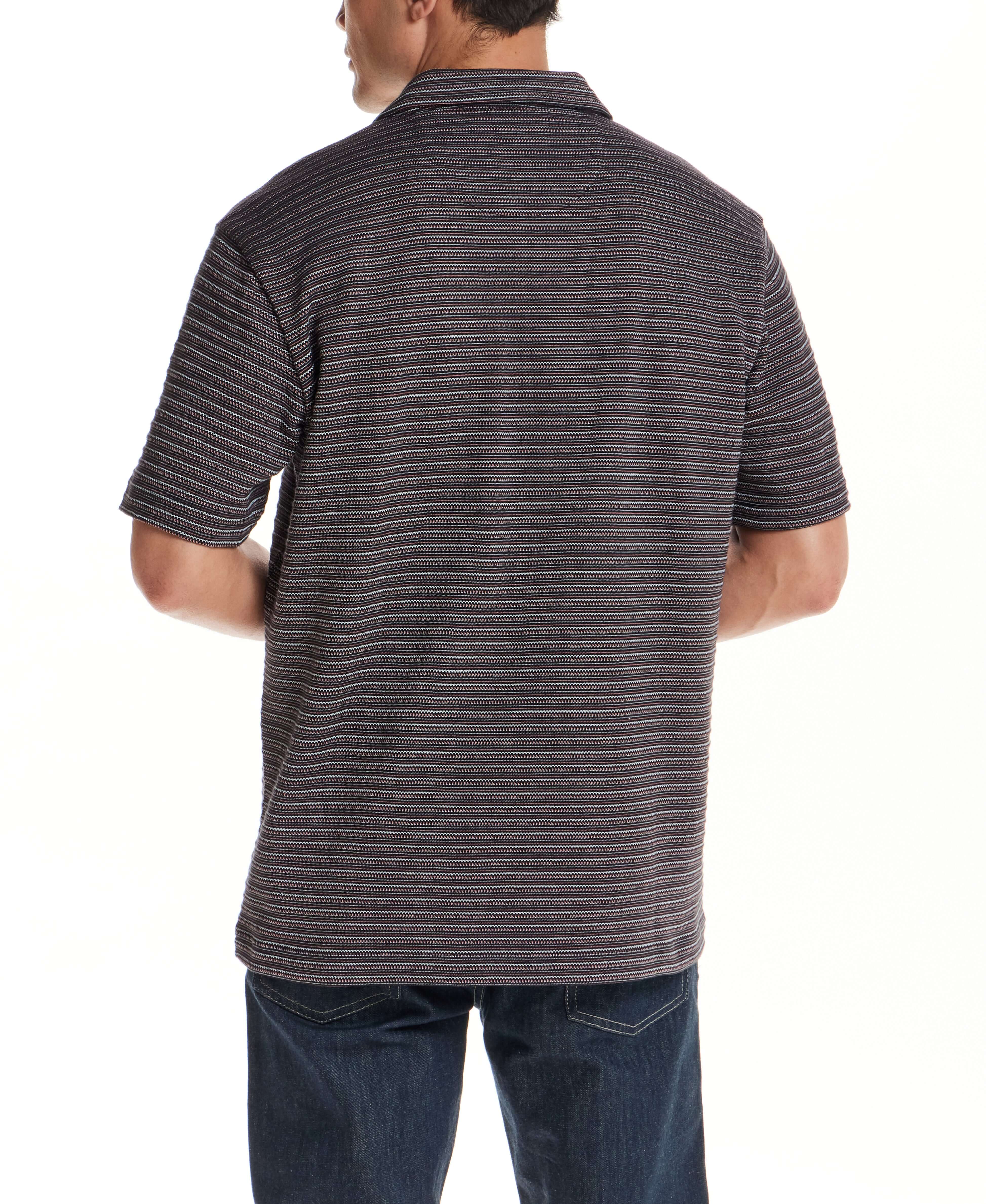 Back view of a man wearing a Jacquard Stripe Polo in Black, showcasing subtle striping texture.