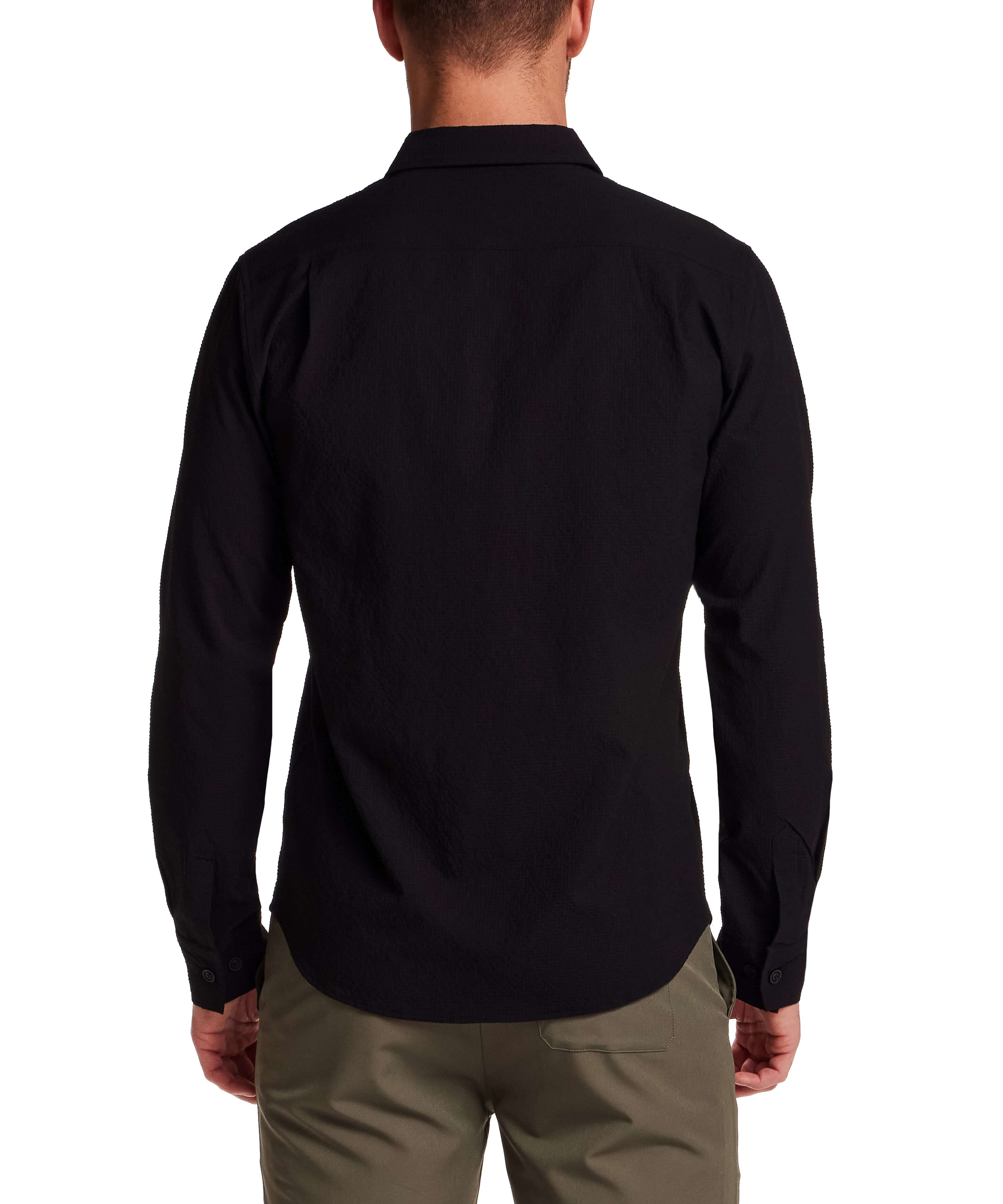 Back view of a man wearing a Seersucker Shirt in Black, showcasing the textured fabric and button-front design.