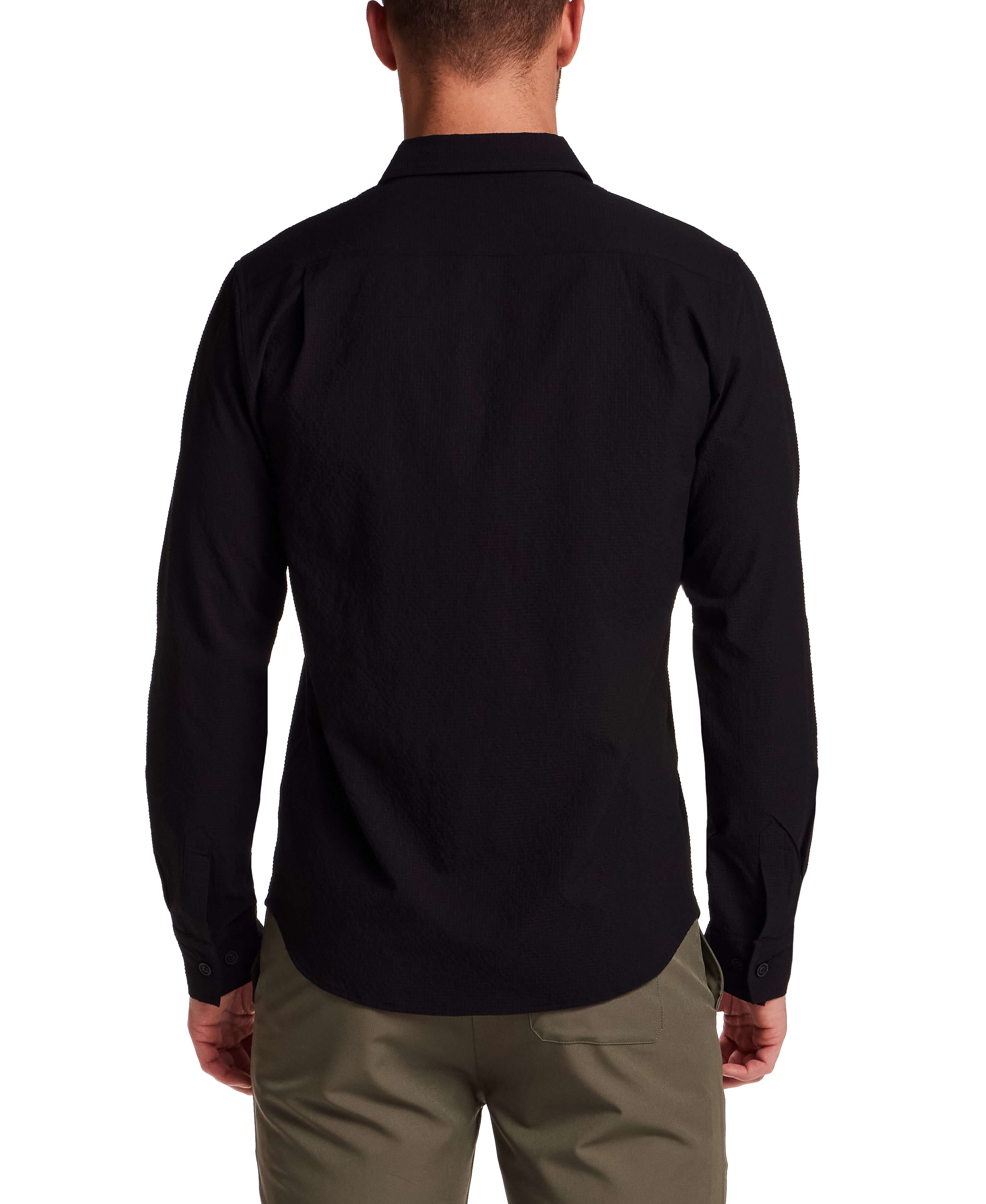 Back view of a man wearing a Seersucker Shirt in Black, showcasing the textured fabric and button-front design.