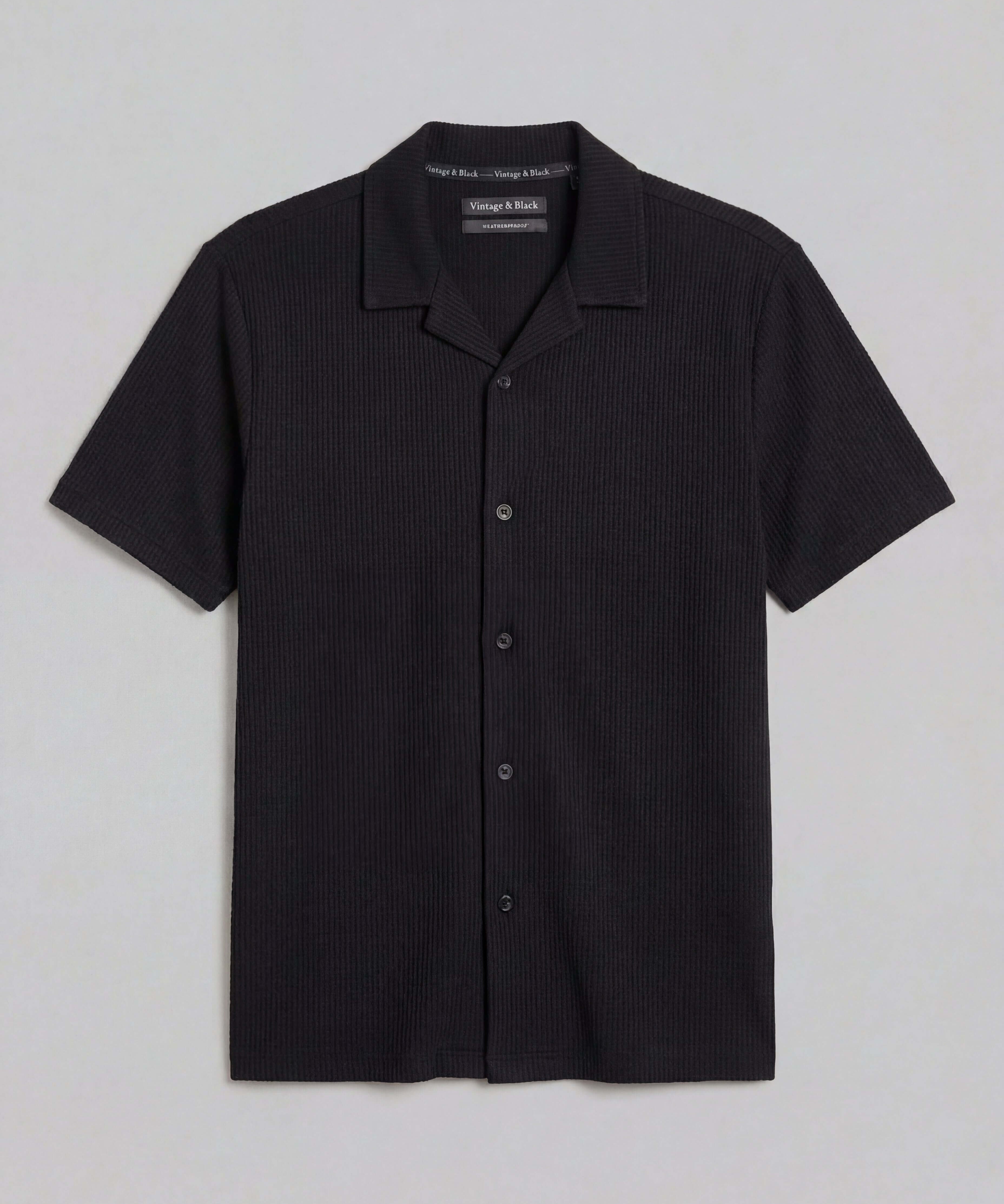 Seersucker Coatfront Knit in Black showcasing a subtle grid texture with a structured collar and button-front closure.
