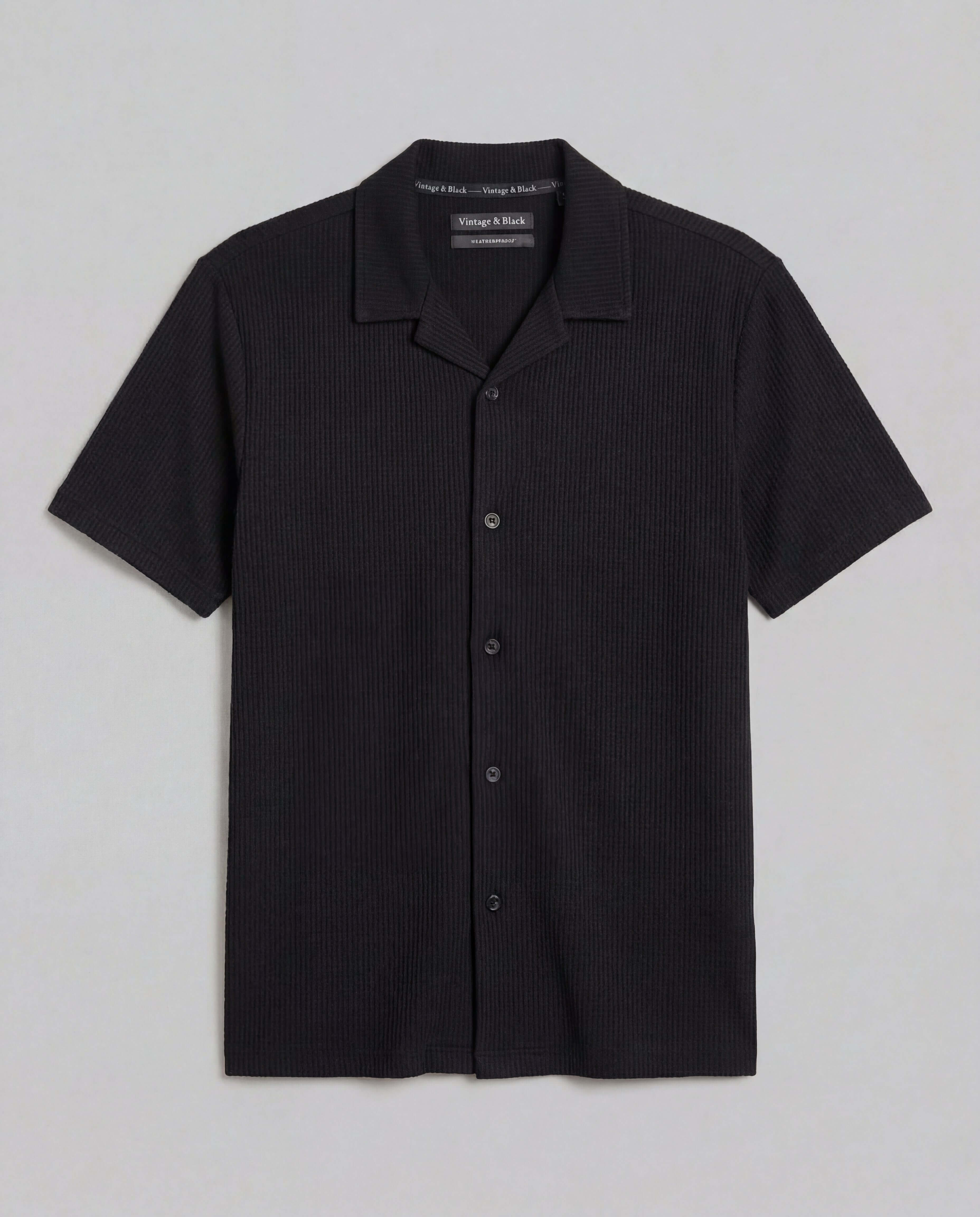 Seersucker Coatfront Knit in Black showcasing a subtle grid texture with a structured collar and button-front closure.