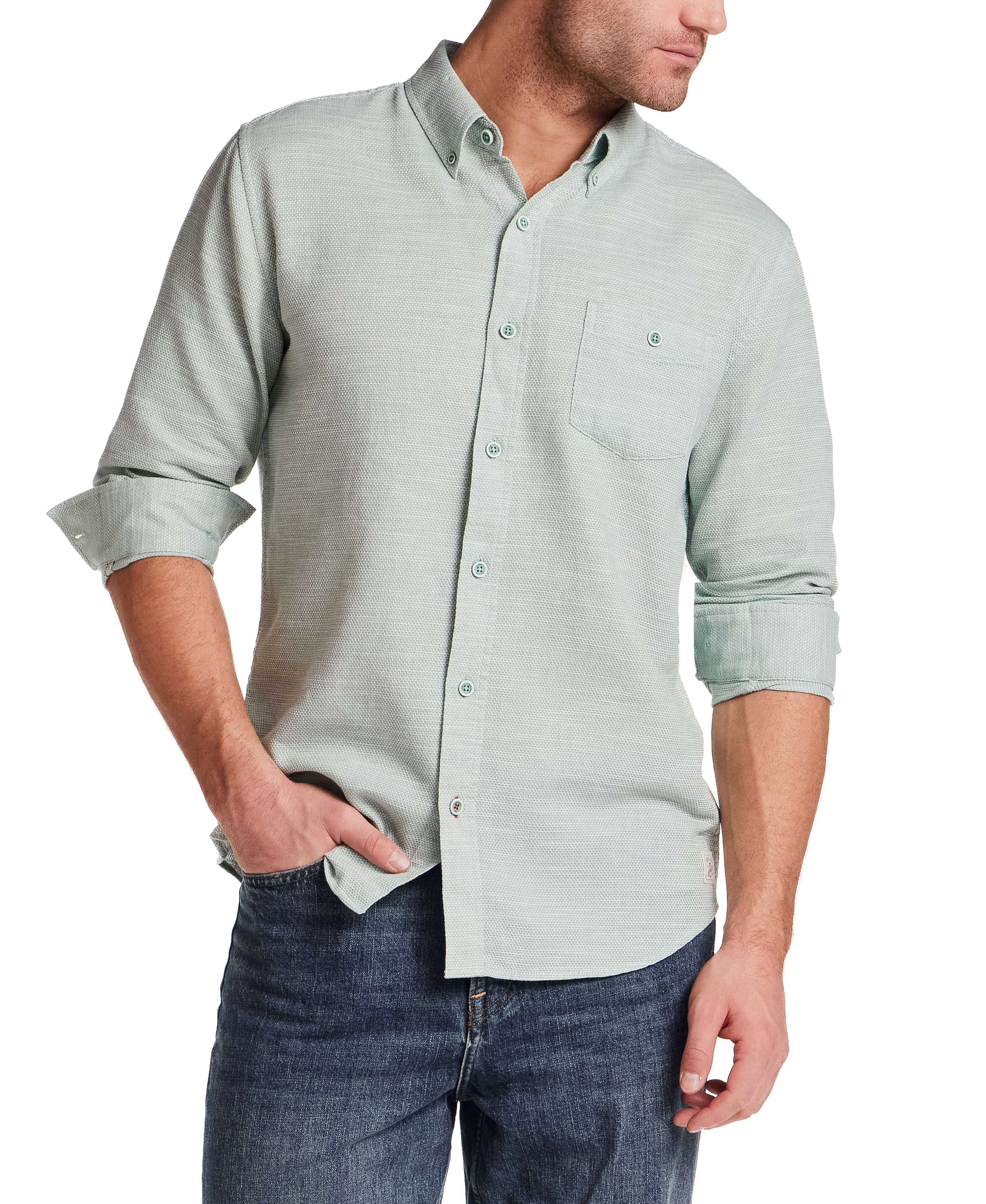 Model wearing Pebble Dobby Button-Down Shirt in Sea Grass, showcasing its button-down collar and chest pocket.