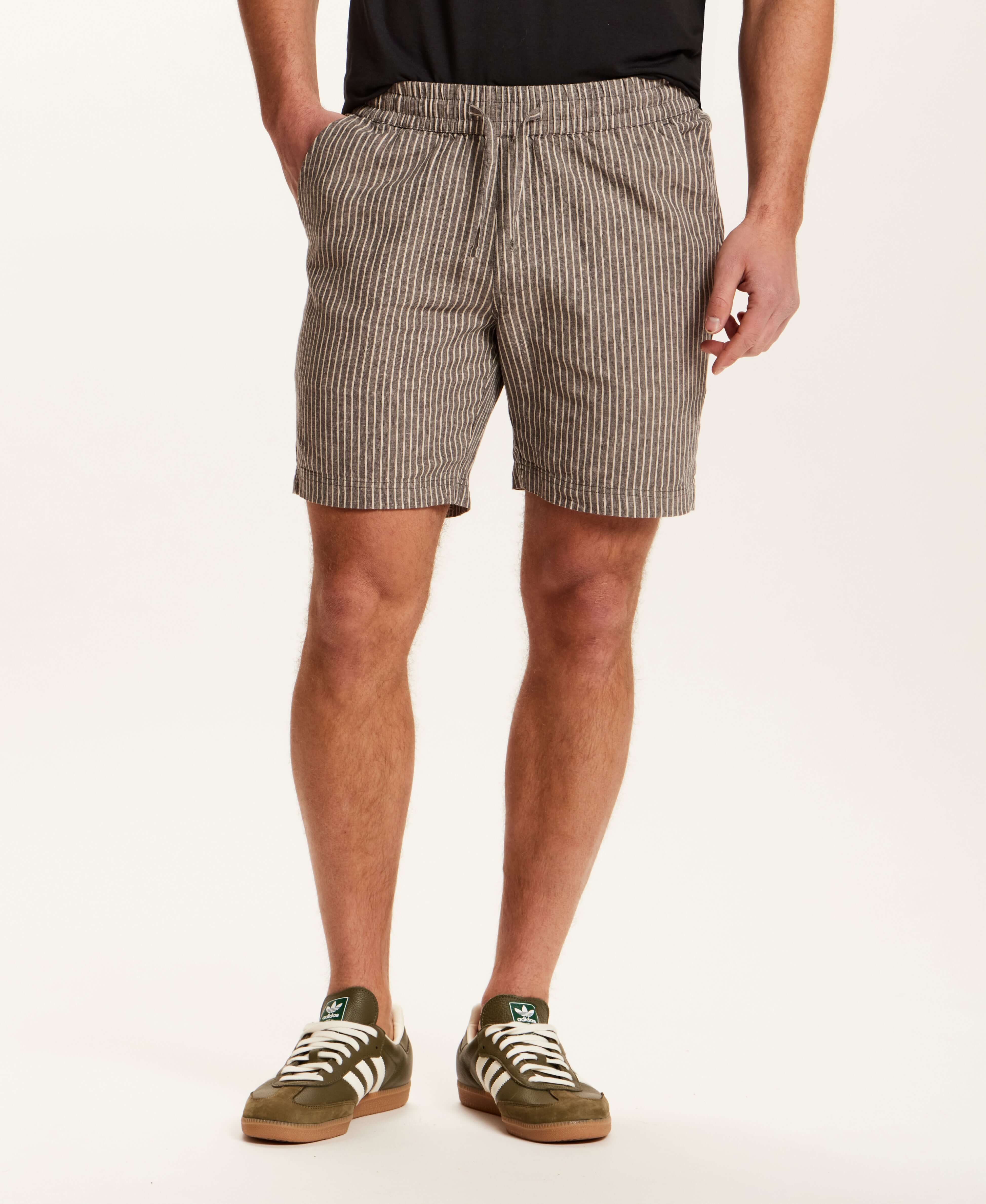 Model wearing Chambray Stripe Drawstring Short in Black Stripe with side pockets and elastic waistband.