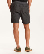 Back view of a man wearing Chambray Stripe Drawstring Short in Black with elastic waistband and side pockets.