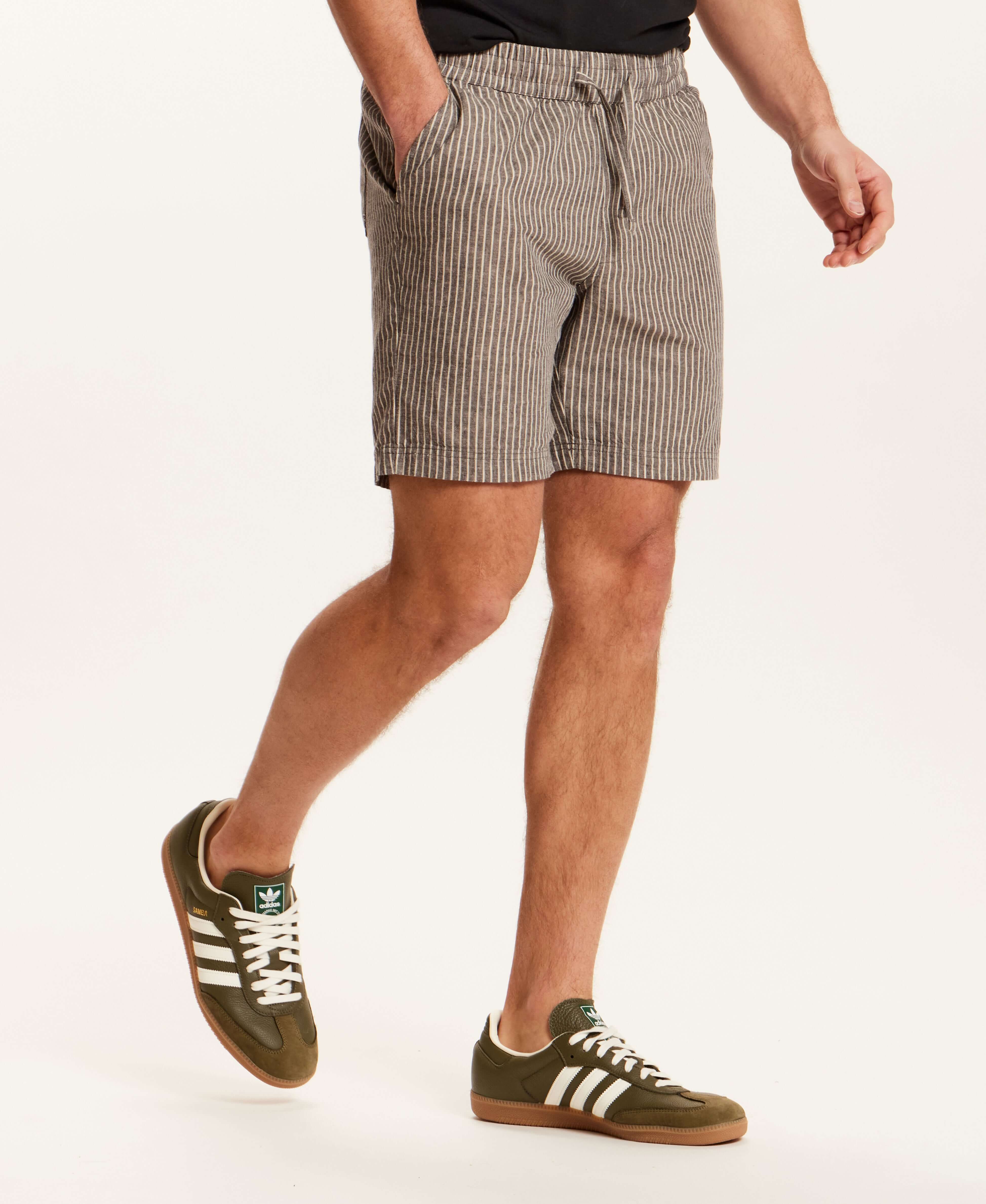 Chambray Stripe Drawstring Short in Black Stripe worn by a model with side pockets and elastic waistband, creating a casual summer look.