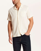 Crinkle Texture Camp Collar Shirt in Cream worn by a man with short sleeves and chest pocket.