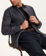Model wearing Long Sleeve Linen Shirt in Grey with button front and relaxed fit, seated on a chair.