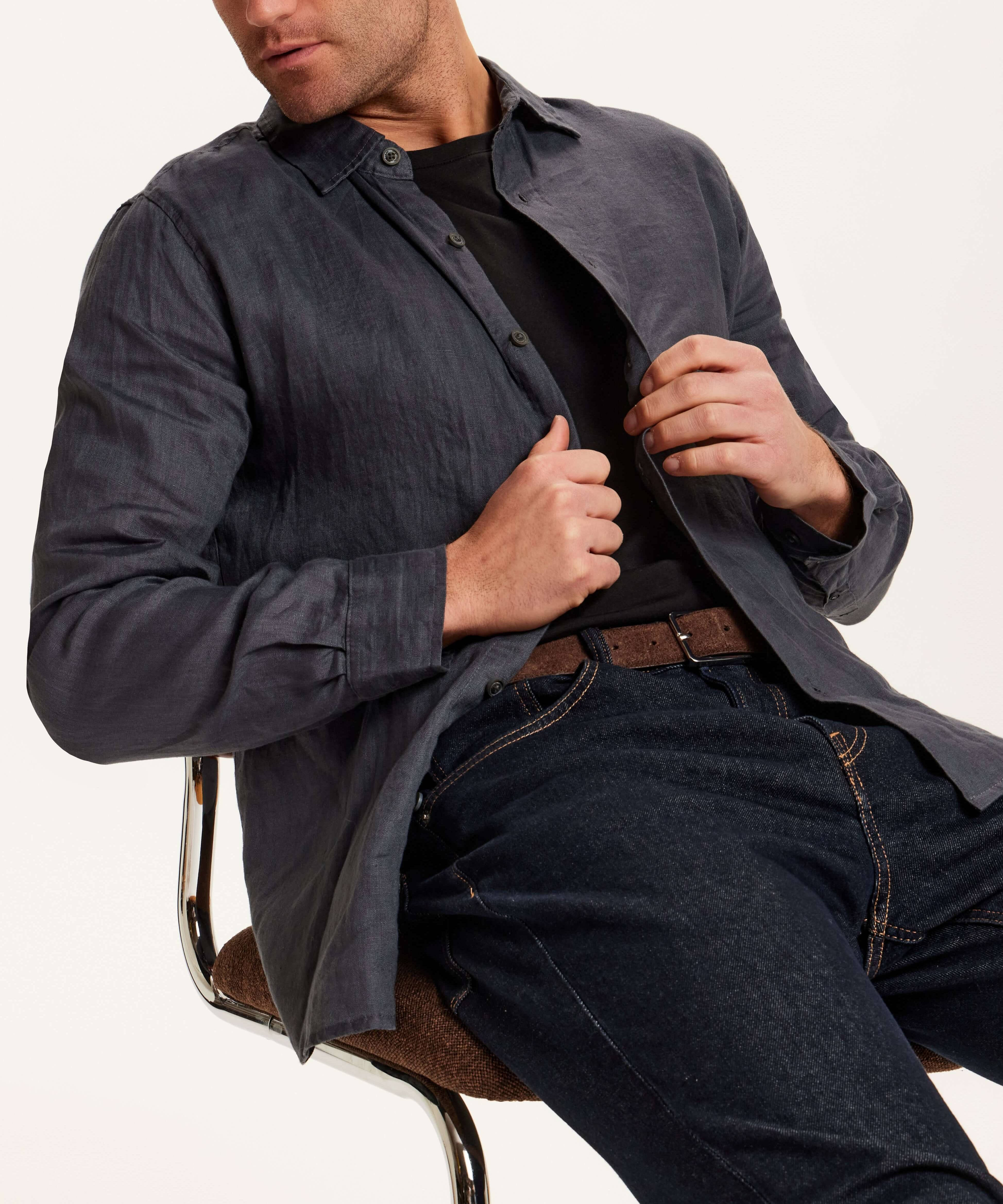 Model wearing Long Sleeve Linen Shirt in Grey with button front and relaxed fit, seated on a chair.