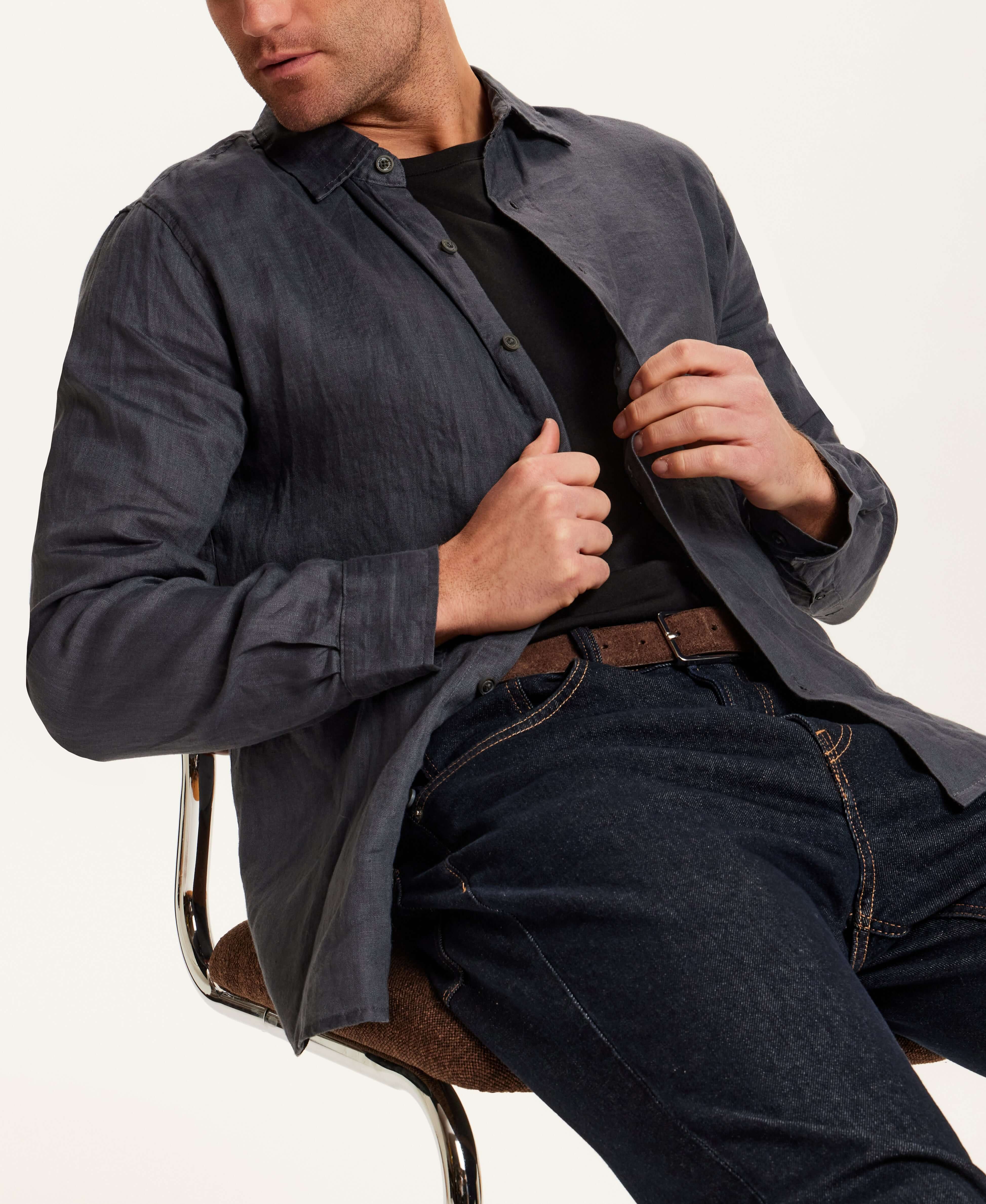 Model wearing Long Sleeve Linen Shirt in Grey with button front and relaxed fit, seated on a chair.