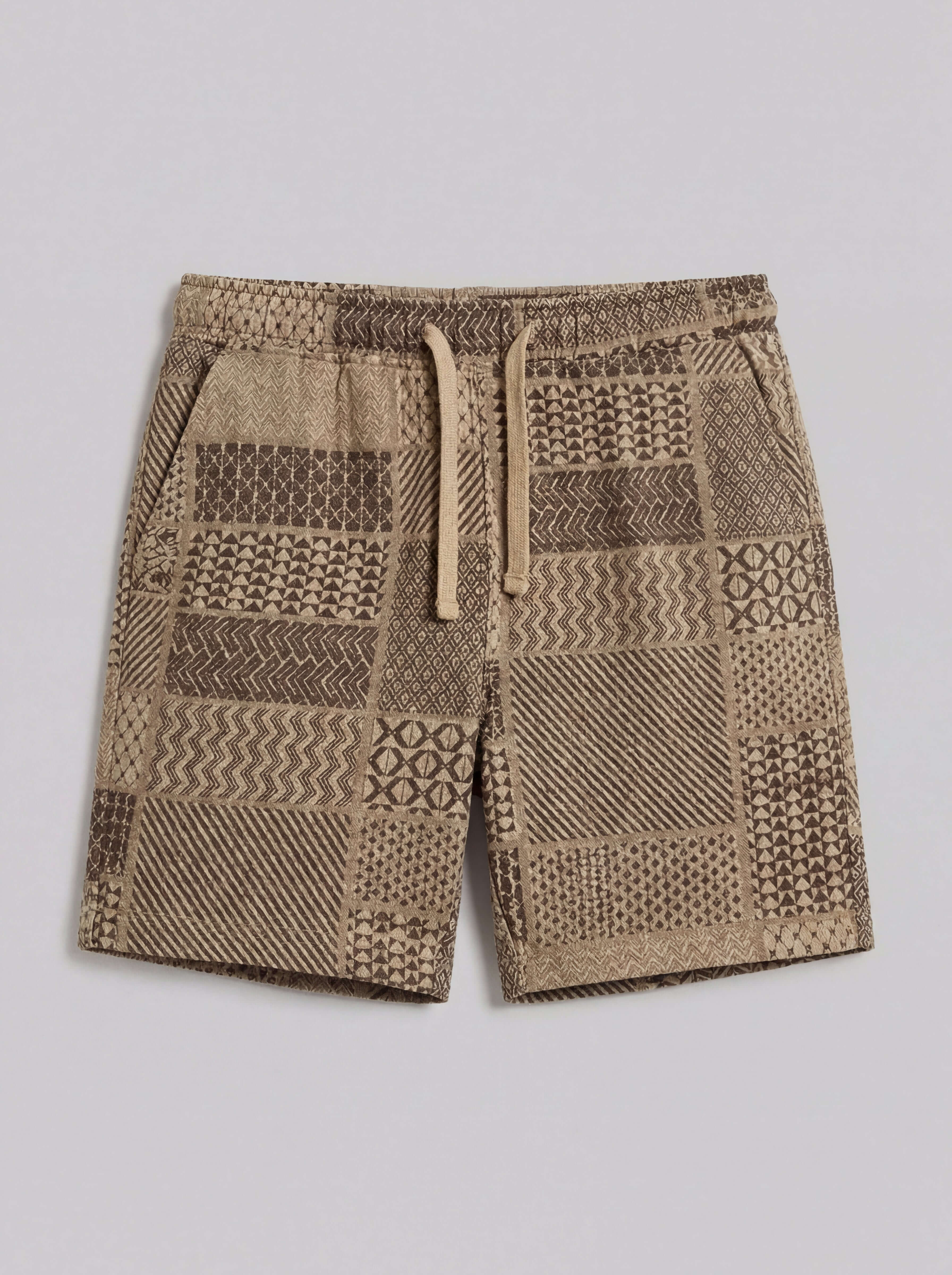 The Patchwork Jacquard Short in Khaki featuring a woven patchwork design and elastic waistband with drawstring.