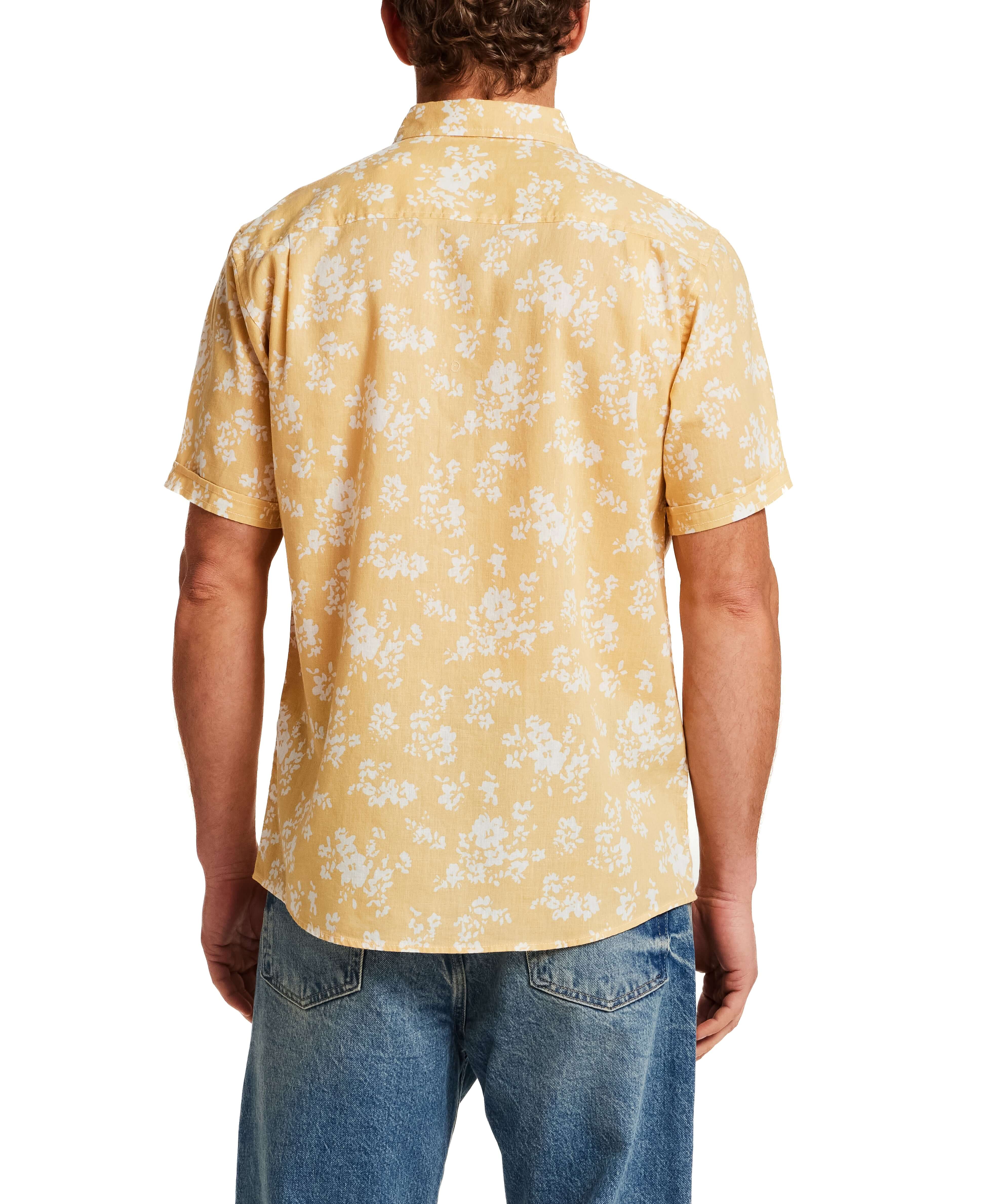 Back view of The Linen Cotton Print Shirt in Misted Yellow featuring a floral print and short sleeves.