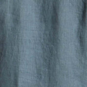 Close-up texture of a soft slate blue fabric, featuring the Short-Sleeve Linen Shirt in Blue.