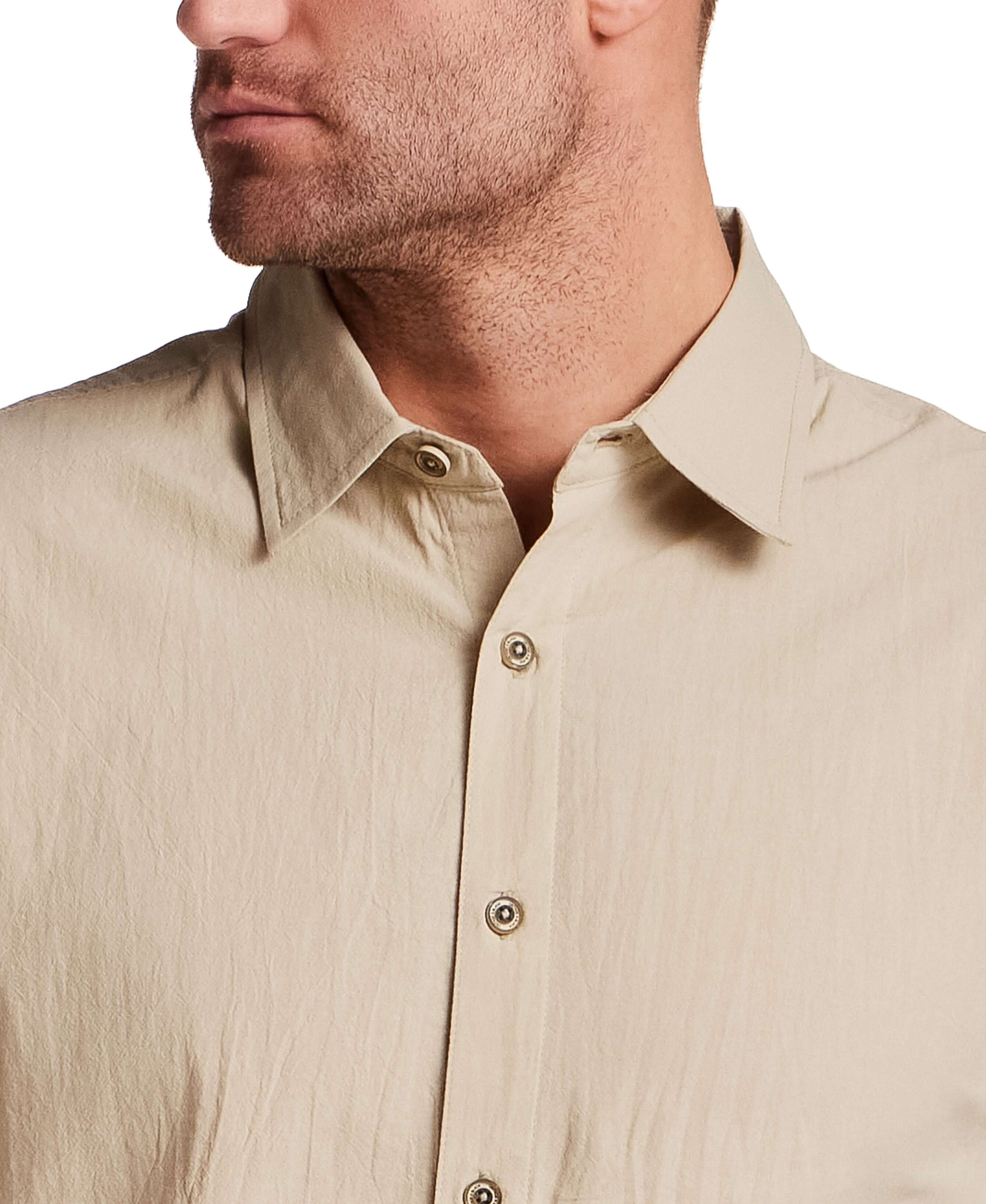 Man wearing a Long Sleeve Cotton Sheeting Shirt in Khaki with button front detail.
