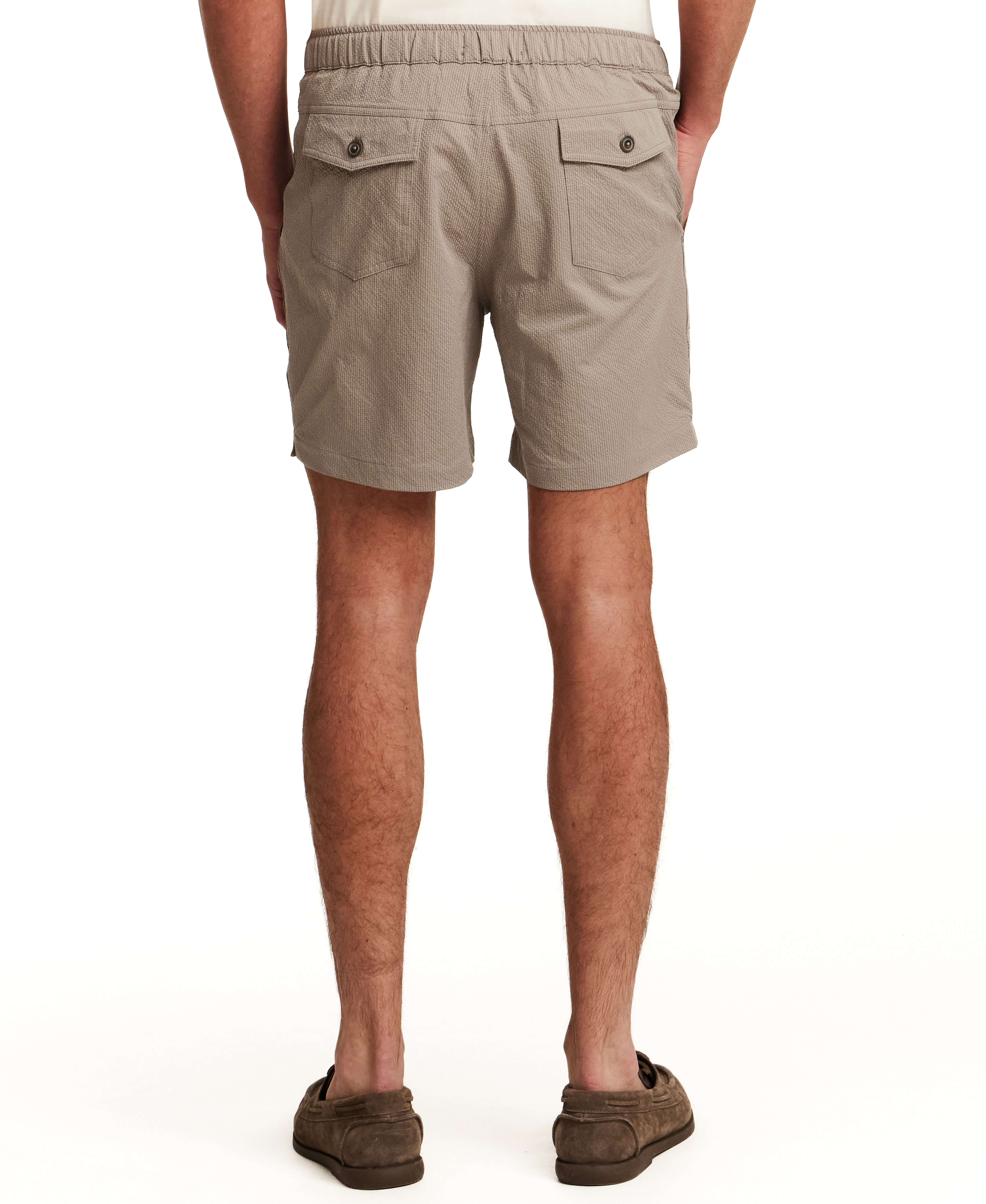 Model wearing Mini Seersucker Short in Khaki from the back, showcasing the elastic waistband and pockets.