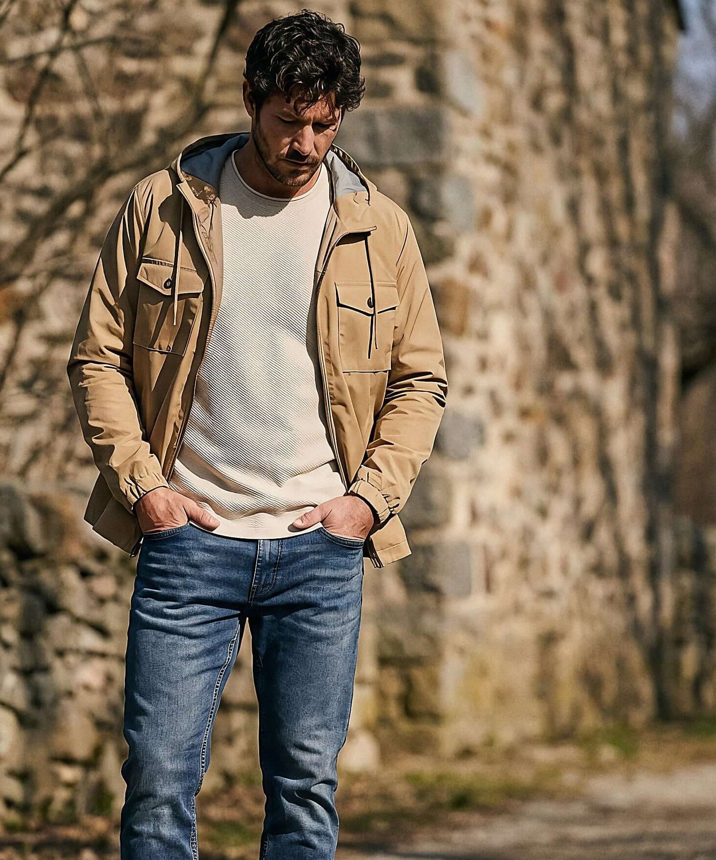 Poly Memory Safari Jacket with Hood in Kelp worn by a man outdoors, showcasing lightweight and stylish design.
